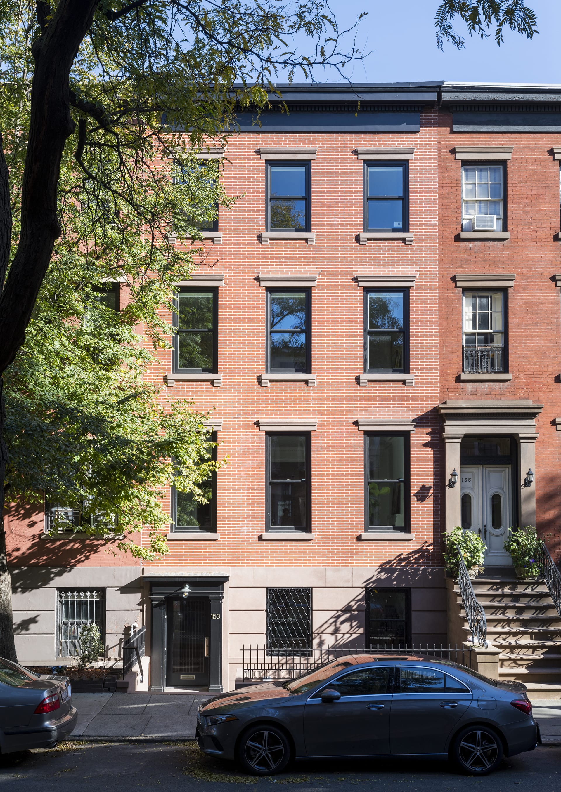 Front façade of a brick townhouse with brownstone lintels and details after our renovation