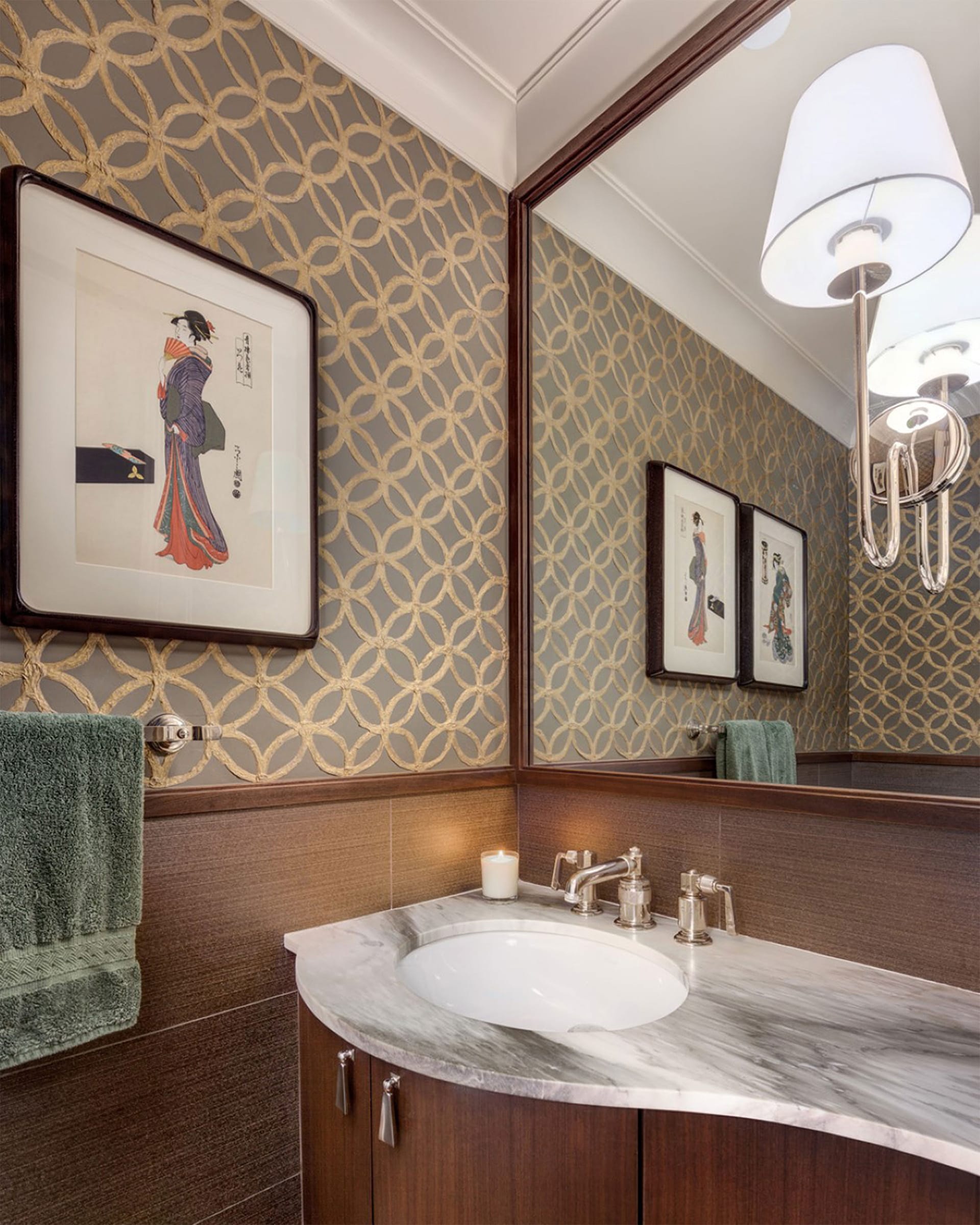 Powder room with wallpapered walls, a marble countertop, two paintings on the wall, and a sconce light