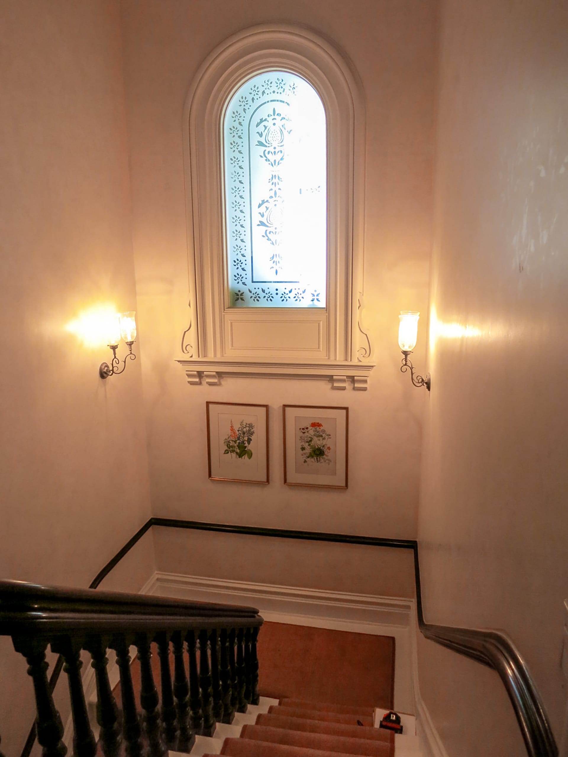 Stair hallway with vintage etched window and red stair runner before renovation