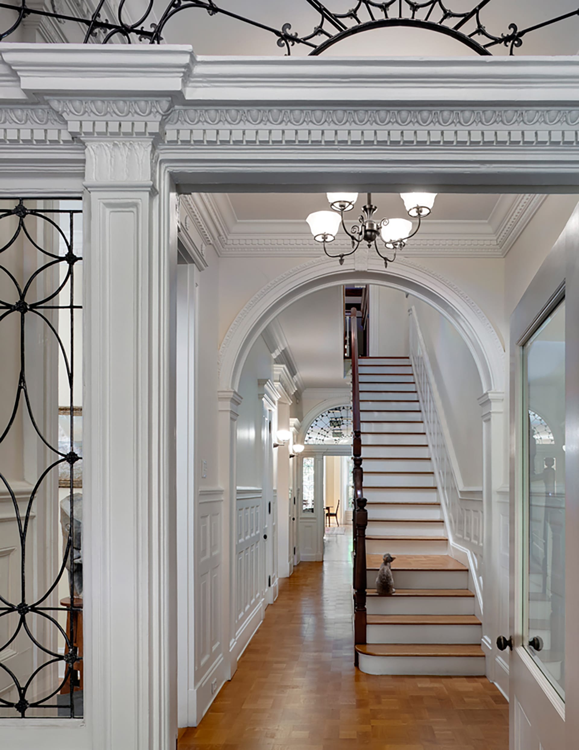 Ironwork, molding, archways, and staircase hallway in a Brooklyn Heights townhouse.