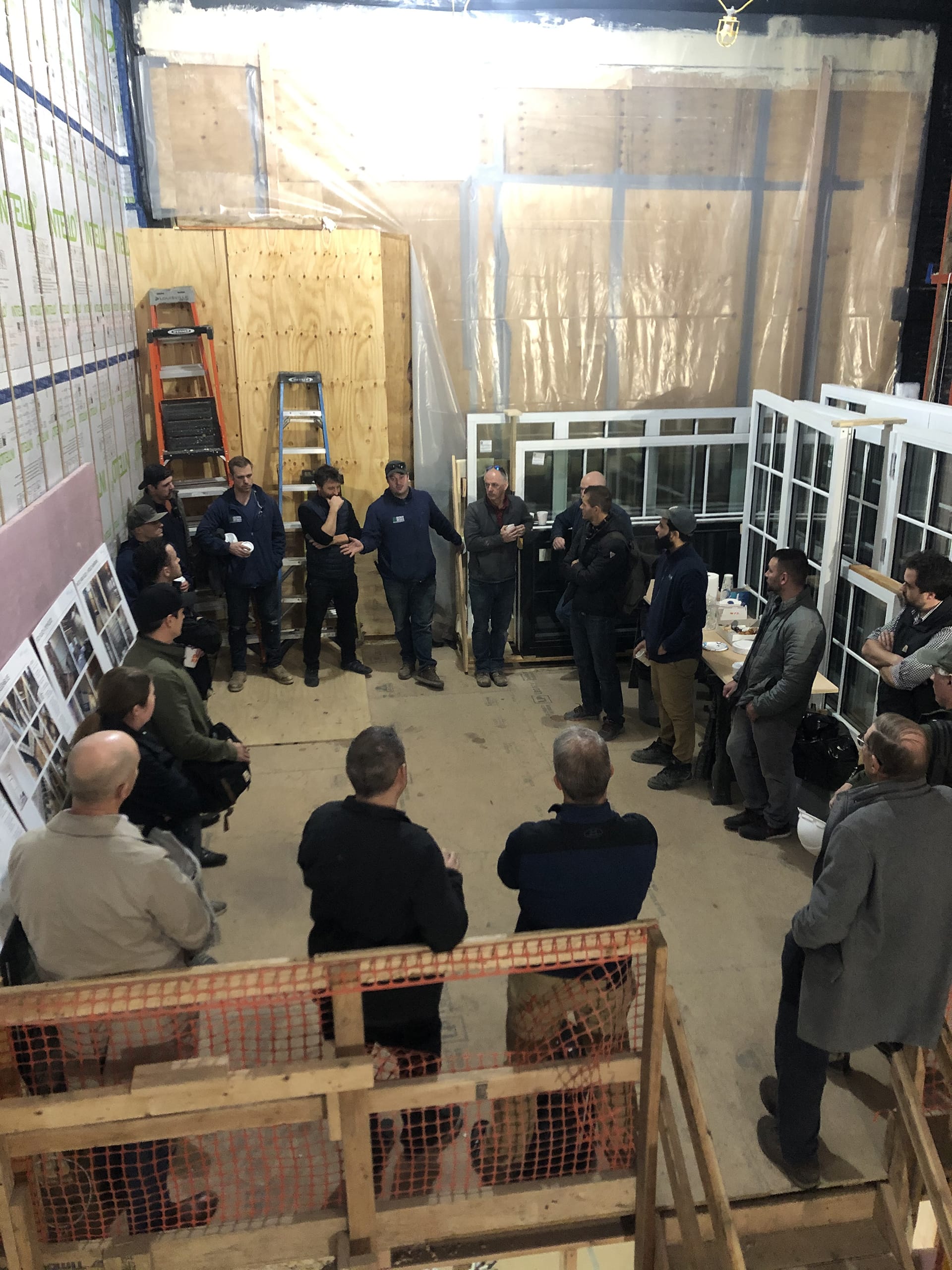 A group of building professionals standing in a circle at a Passive House job site in Brooklyn