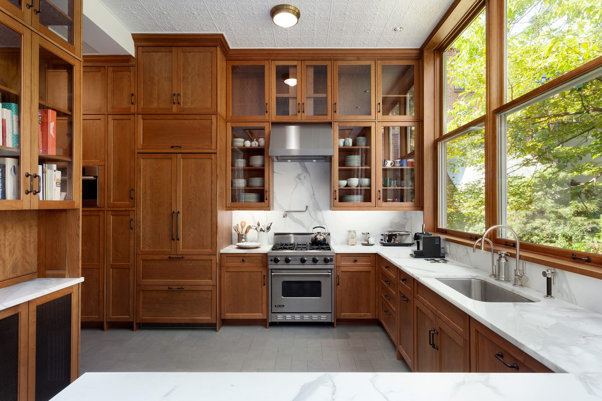 Kitchen with natural wood cabinetry, stainless steel appliances, and white marble countertops in a Brooklyn Heights townhome