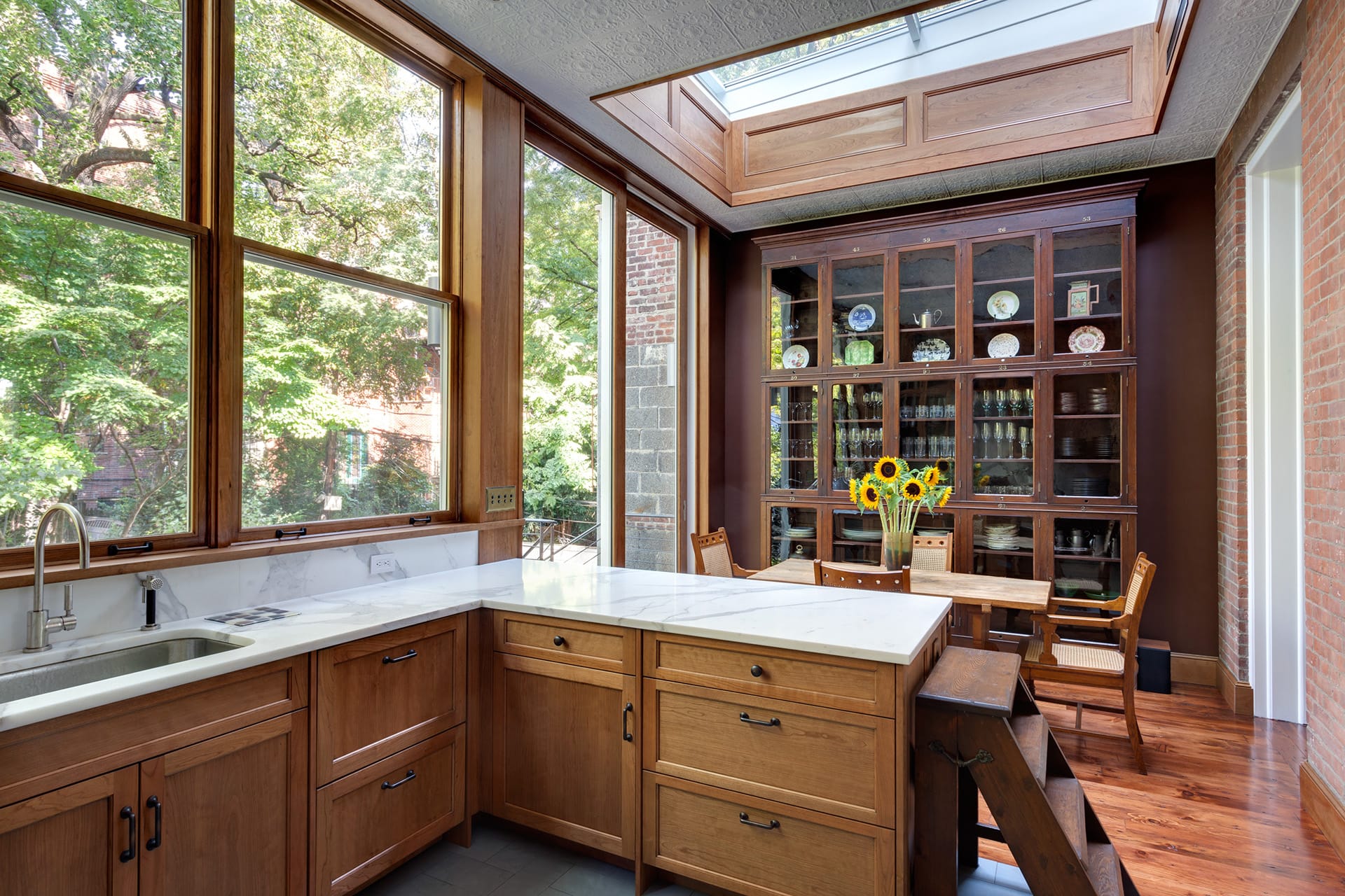 Kitchen with natural wood cabinetry, a skylight, and white marble countertops in a Brooklyn Heights townhome