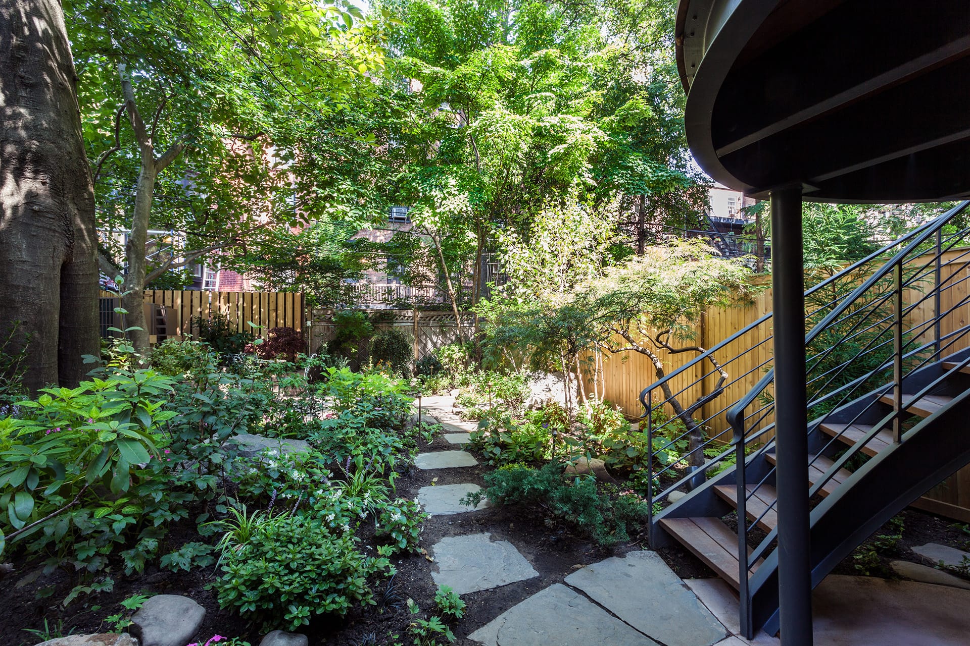 Rear garden of a Brooklyn Heights home with a staircase leading to the parlor-level deck