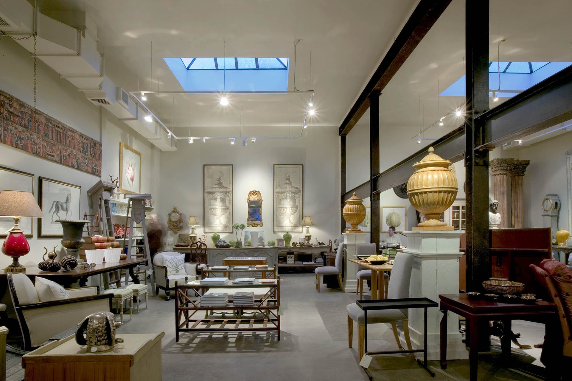 Antique store showroom with decorative and structural iron beams and two large skylights.