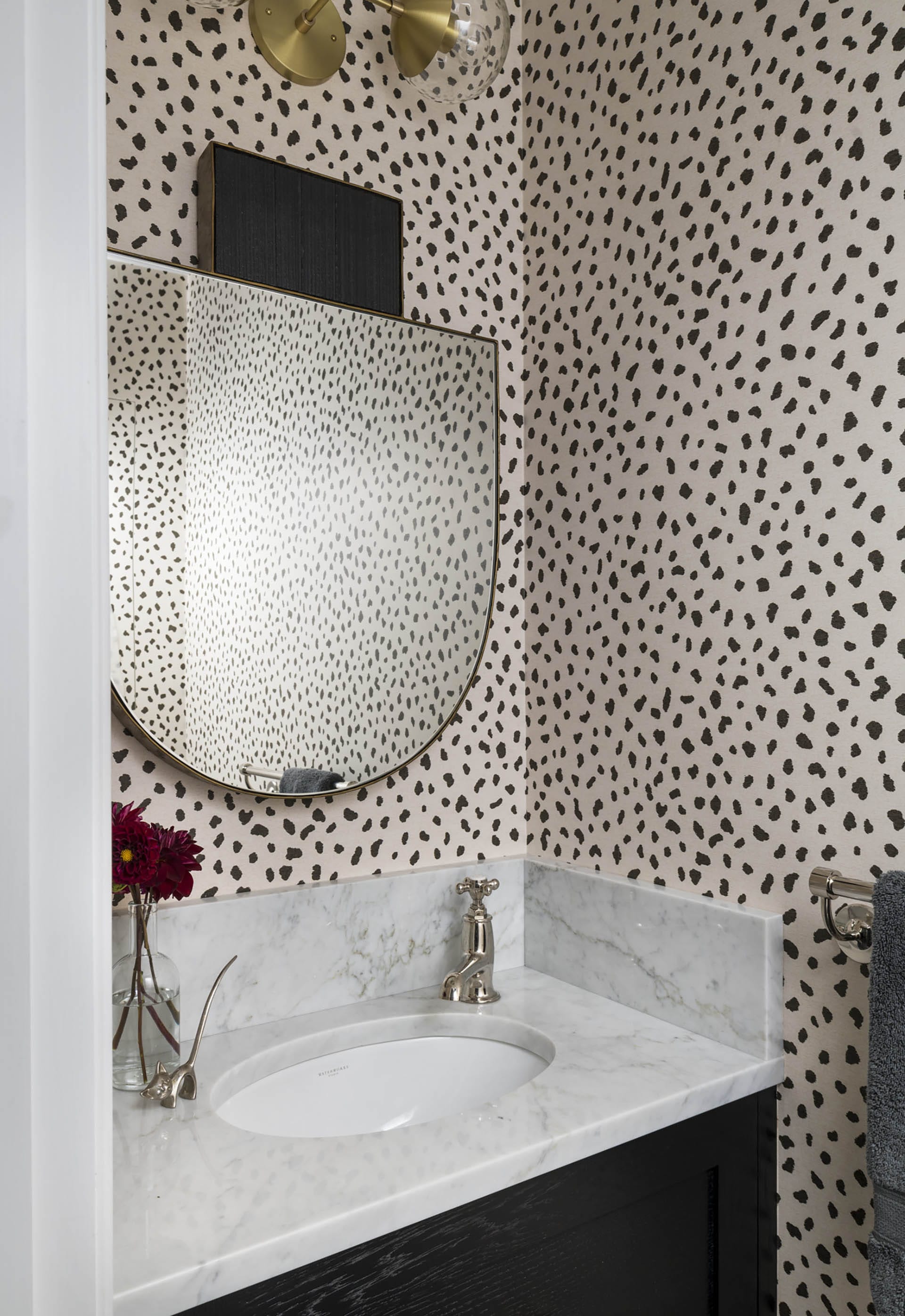 Brooklyn Heights powder room with organic spotted wallpaper, a marble countertop, and statement mirror