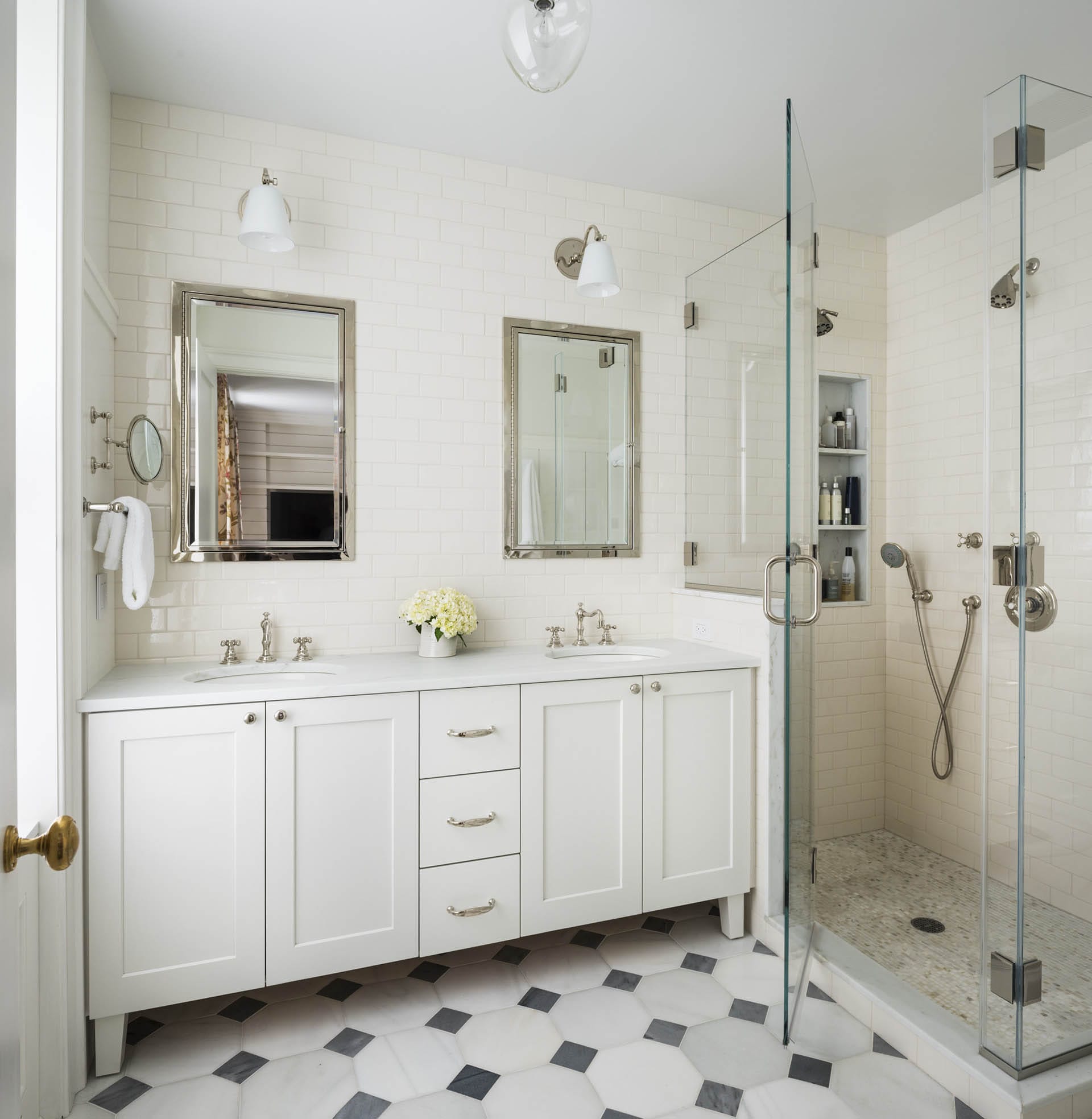 Primary bathroom with tiled floors, subway tiles on the wall, and a white Jack and Jill vanity