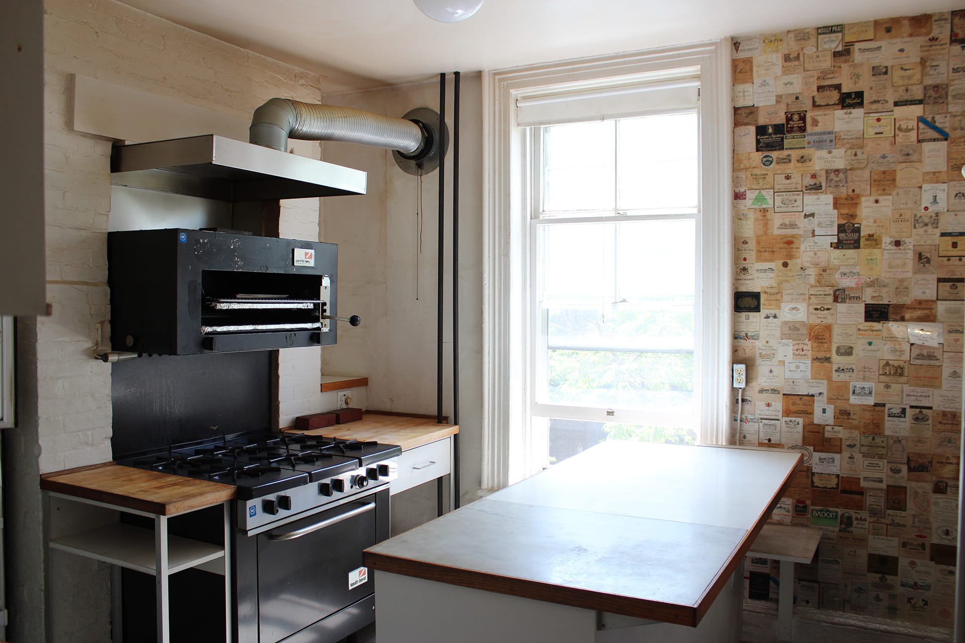 Kitchen with a wall of wine labels before our renovation