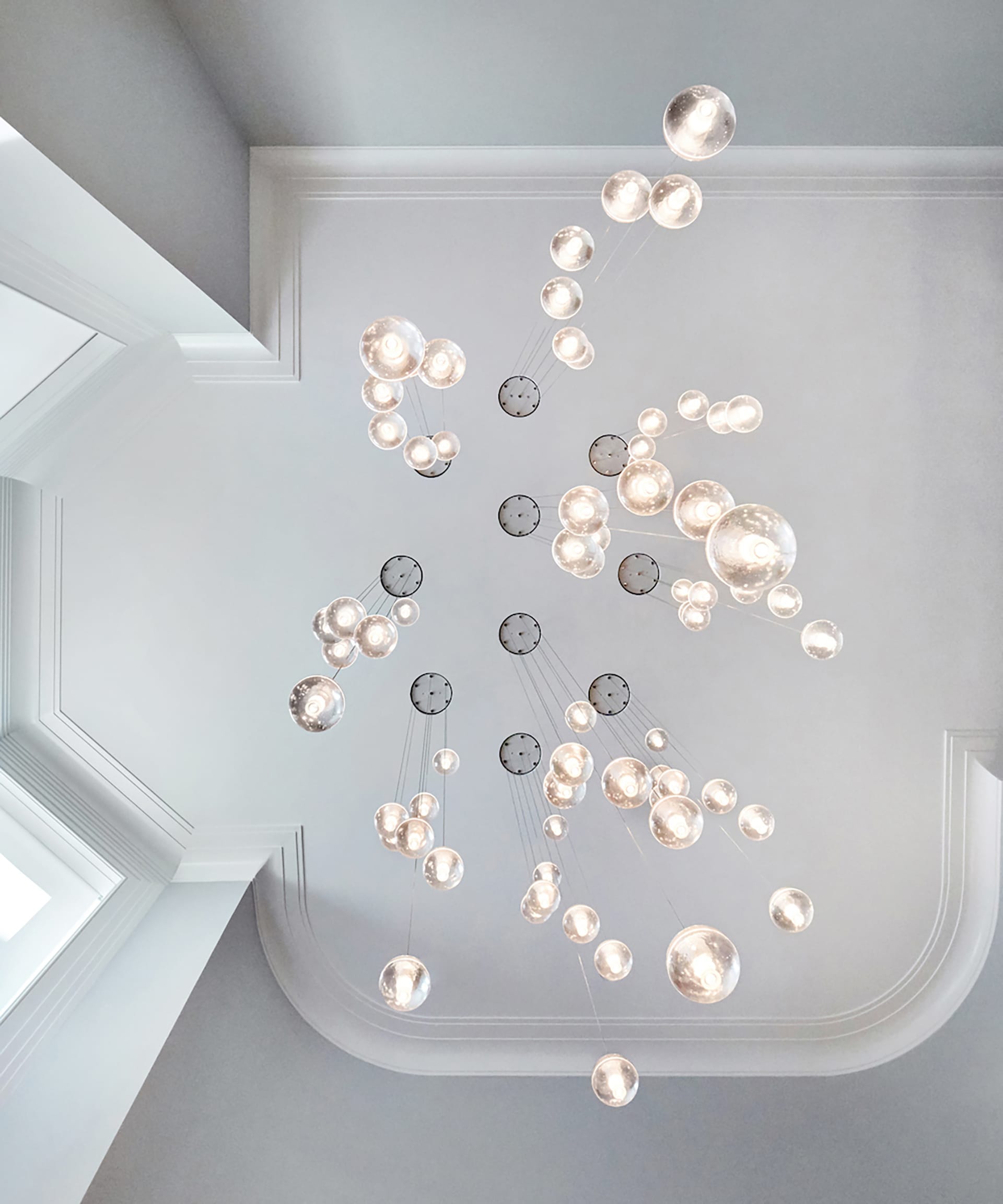 Looking up at a Bocce light fixture installation.