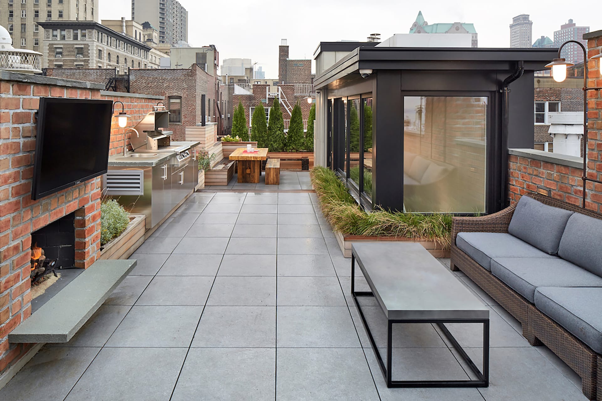Rooftop with a black bulkhead, bluestone pavers, and an outdoor kitchen.