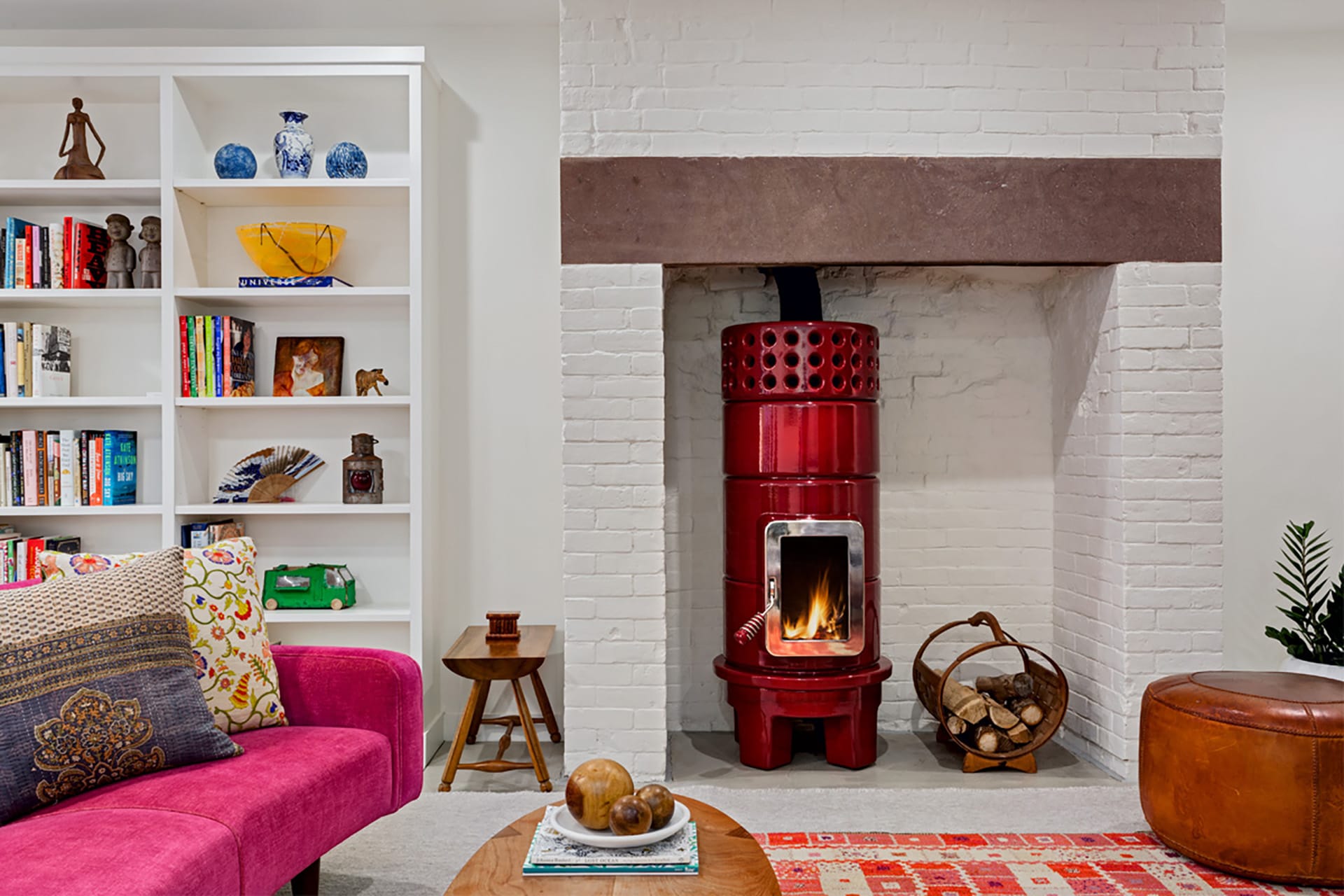 Bright red Scandinavian fireplace in the garden-level living room of a Brooklyn Heights townhouse