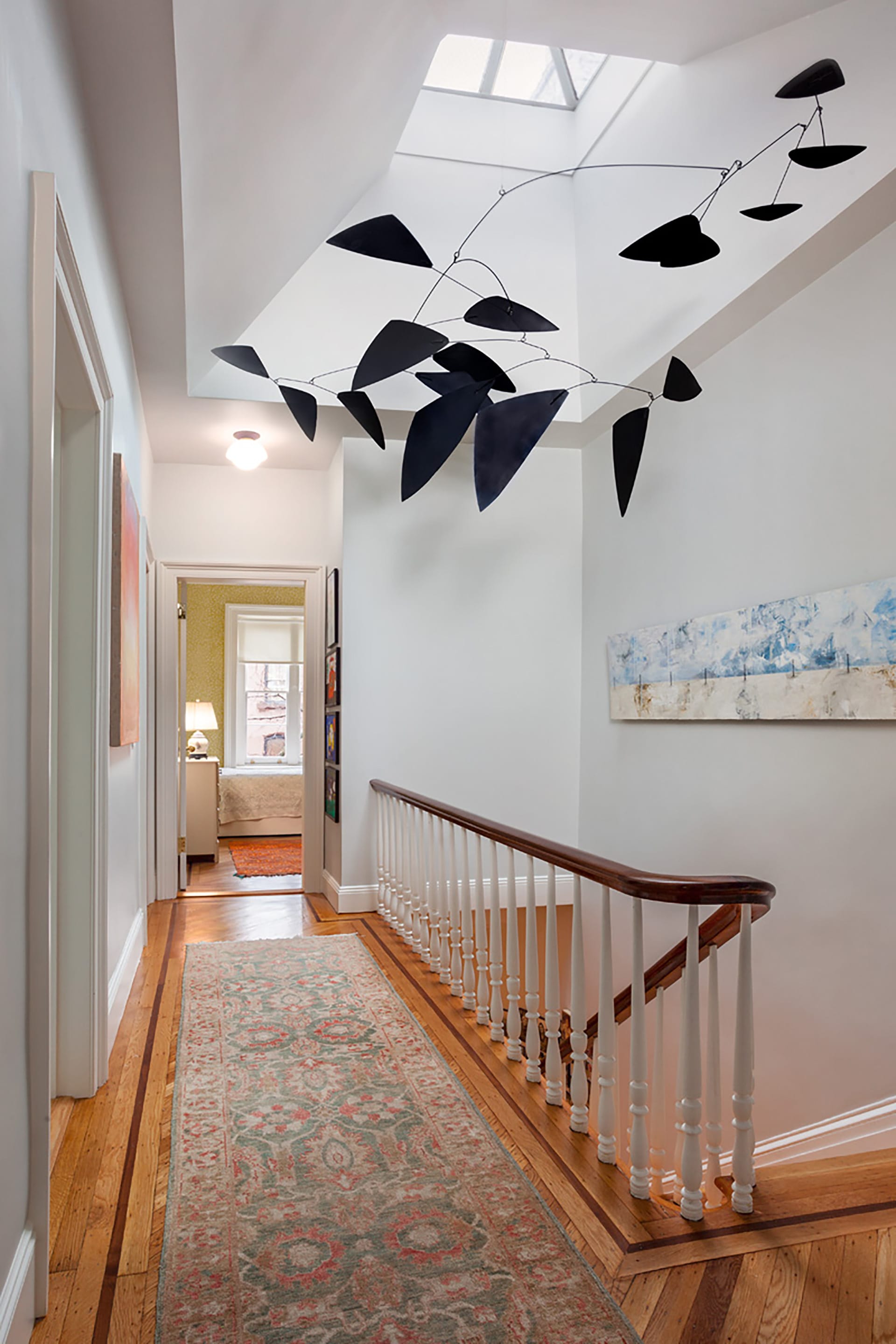 Newly splayed skylight with a hanging sculpture above the main staircase of a Brooklyn Heights home