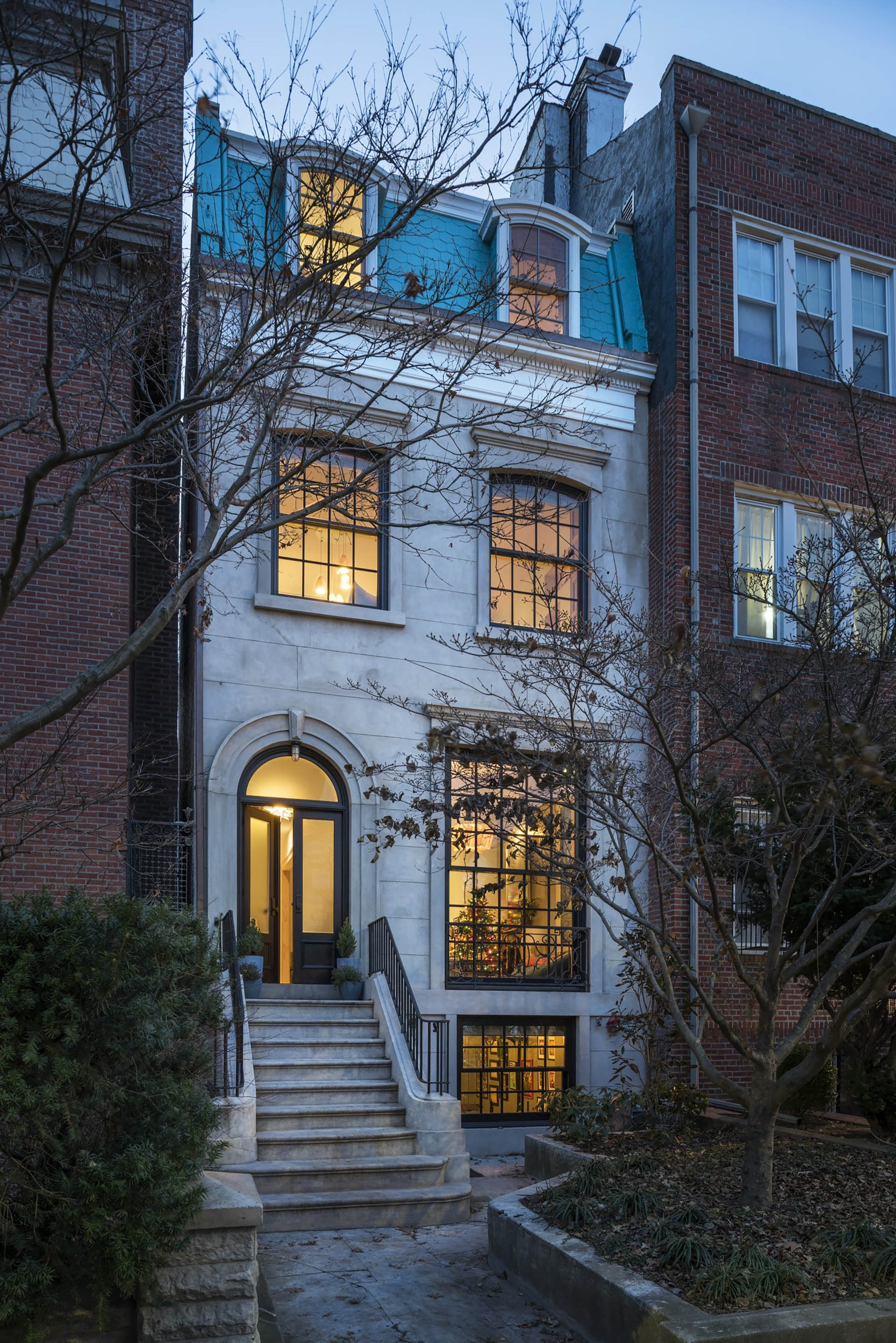 Front façade of a stucco Clinton Hill rowhome with light blue painted shingles.