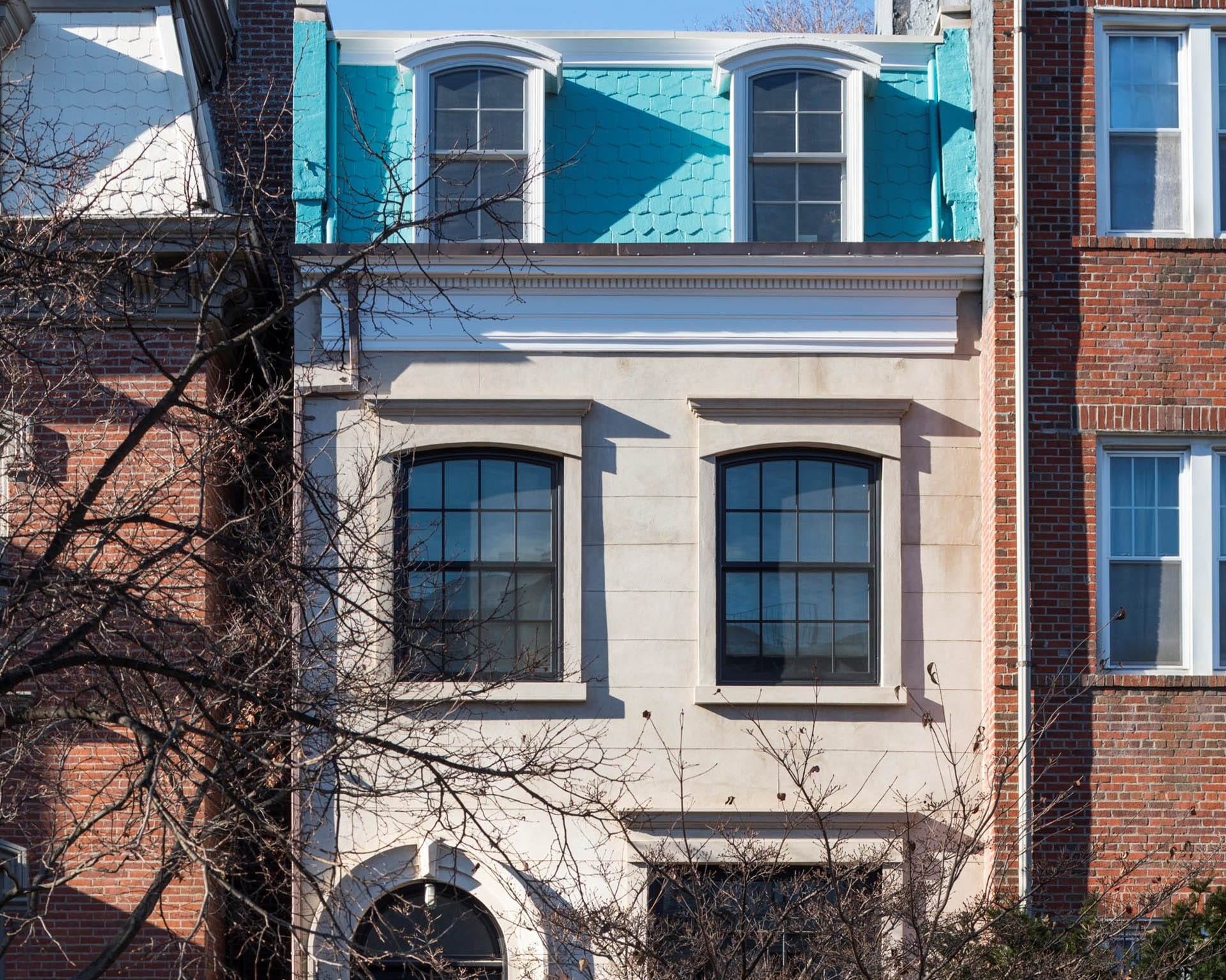 Bright blue cornice atop a limestone rowhouse in Clinton Hill, New York.