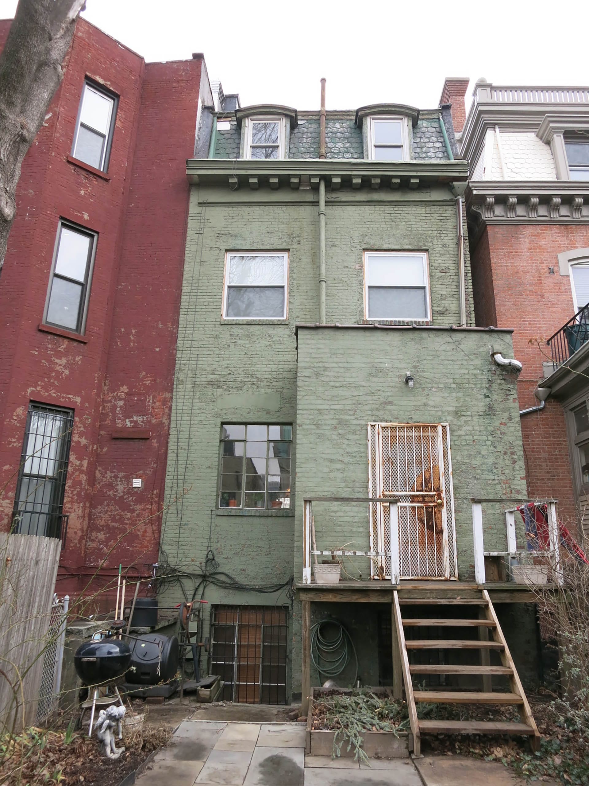 Painted brick rear facade of a Clinton Hill rowhome before our renovation.