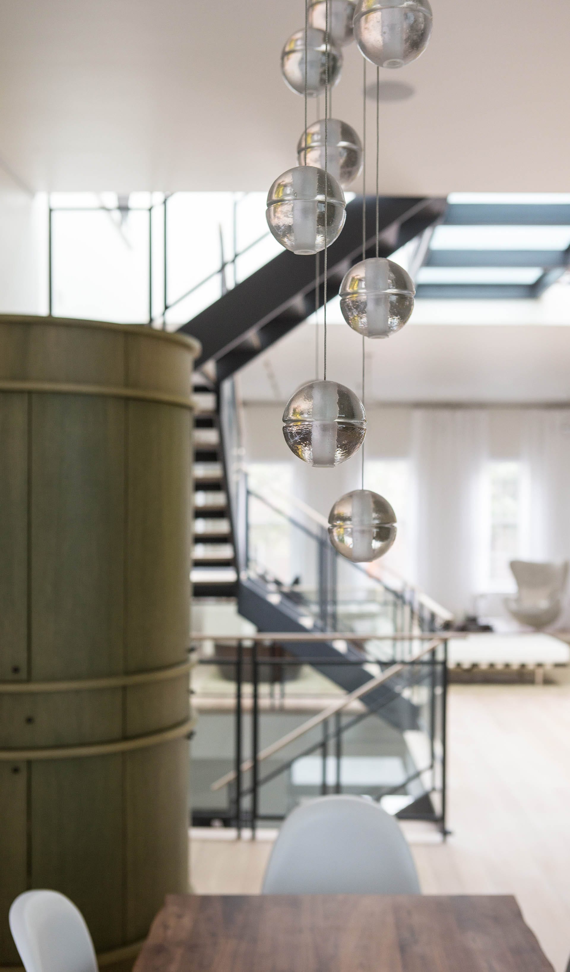 Bocce light display hanging over the kitchen table, next to an artisan-crafted pantry.