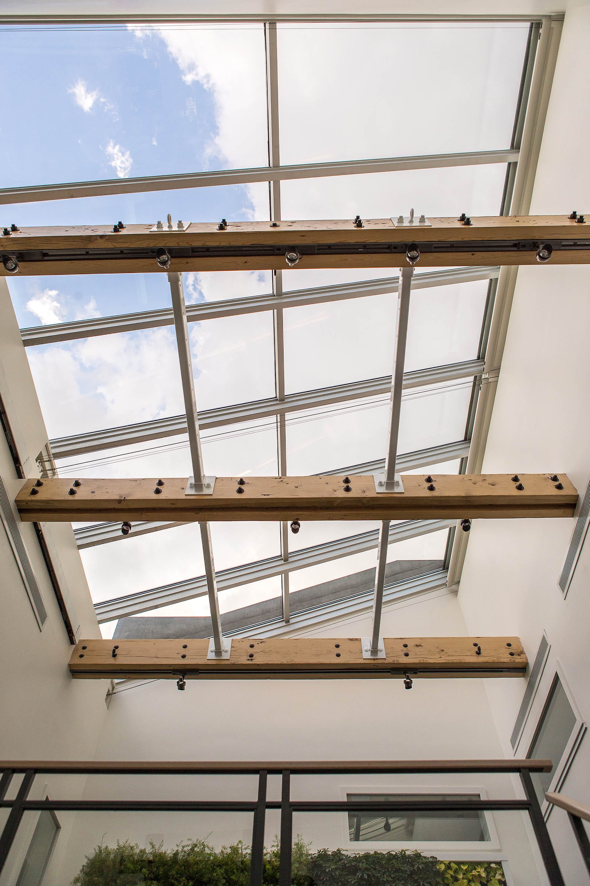 Large skylight with wooden beams supporting track lights.