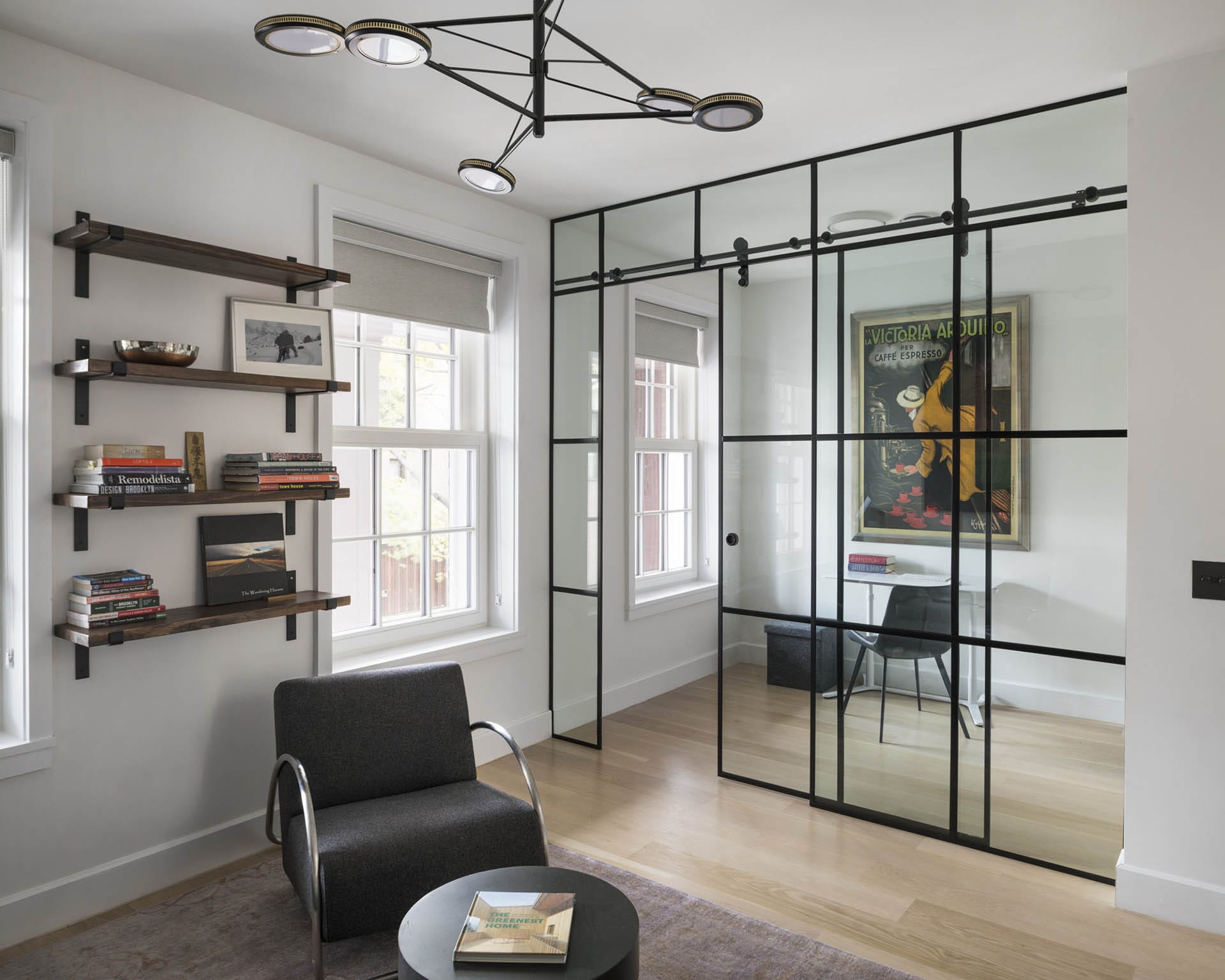 Study with modern light fixture and glass-and-metal privacy wall.