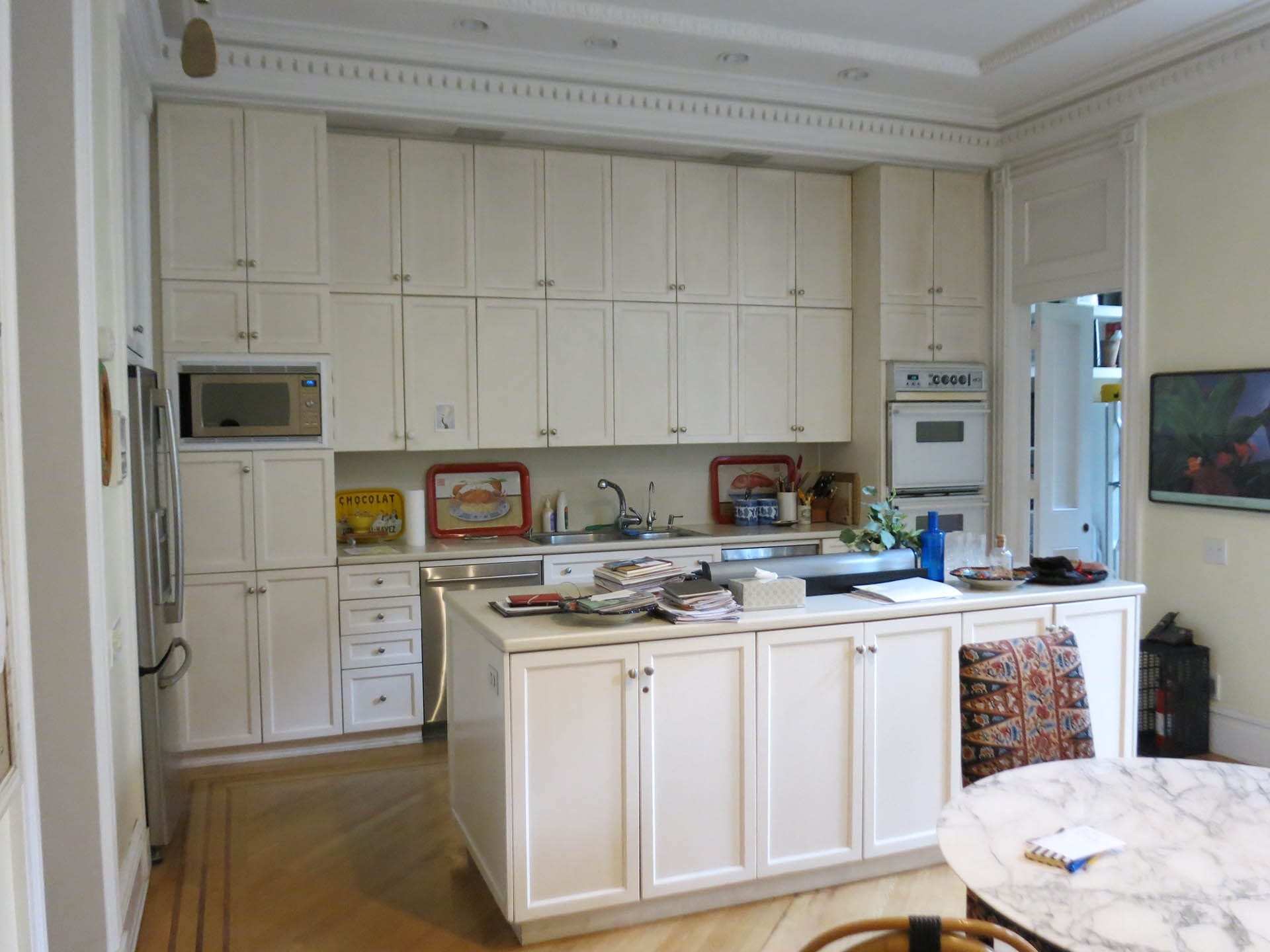 All white kitchen with shaker-style millwork on the cabinets, walls, and island.