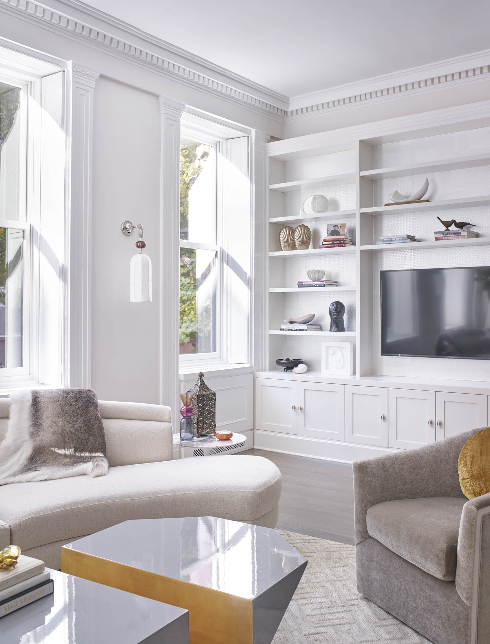 Living room with preserved historic details, white walls, and eclectic modern furnishings.