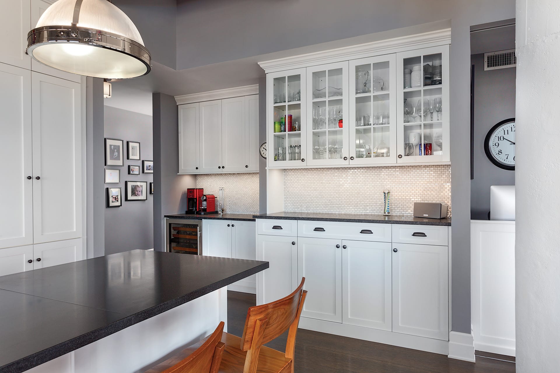 Bar area in a kitchen with white cabinetry, mosaic tile backsplash, and grey painted walls