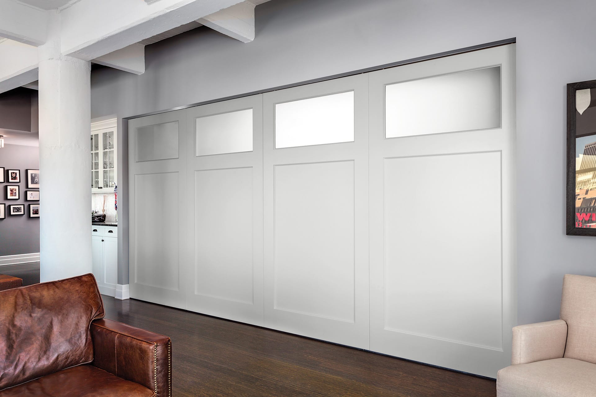 Four large pocket doors conceal an entertainment room from the living space adjacent to it.