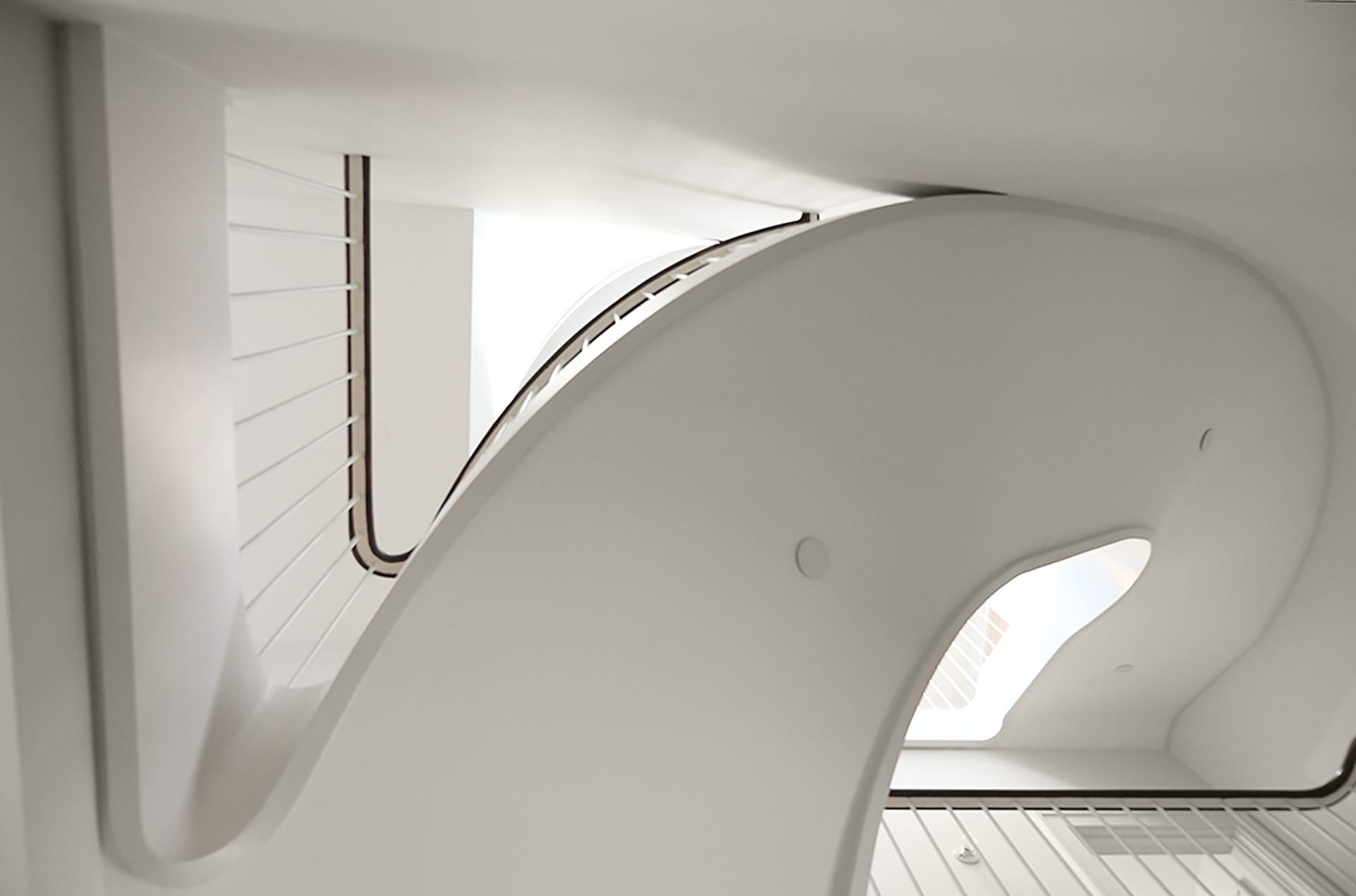 Detail shot of a sculptural white staircase, looking up from below
