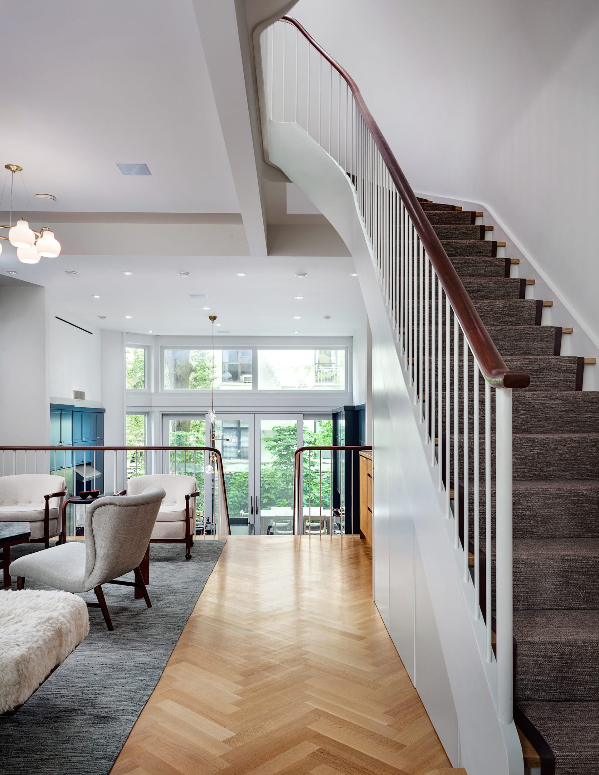 Landing of a sculptural staircase leading to the double-height kitchen.