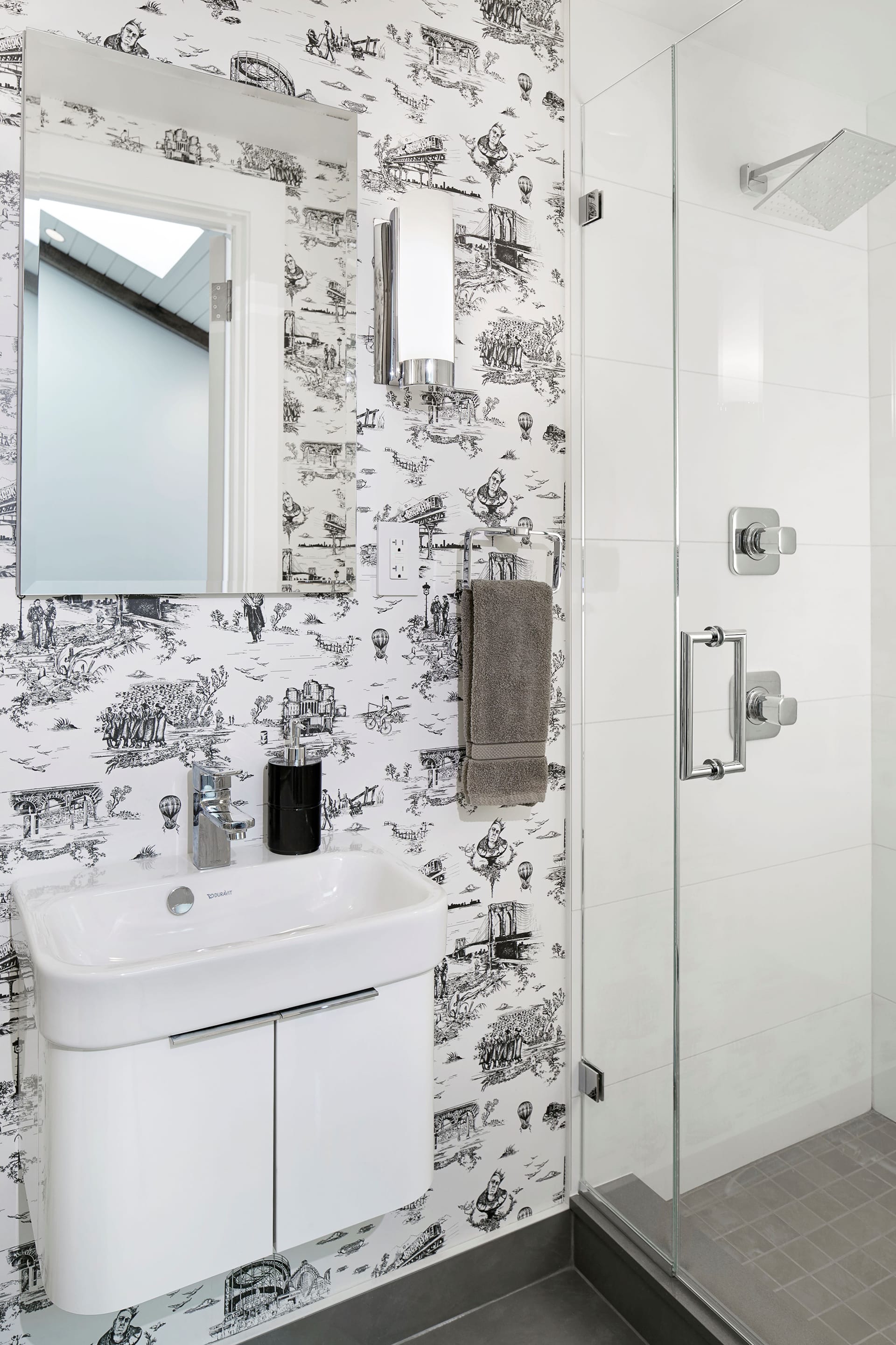 Bathroom with a shower stall, grey tile photos, and black and white patterned wallpaper.