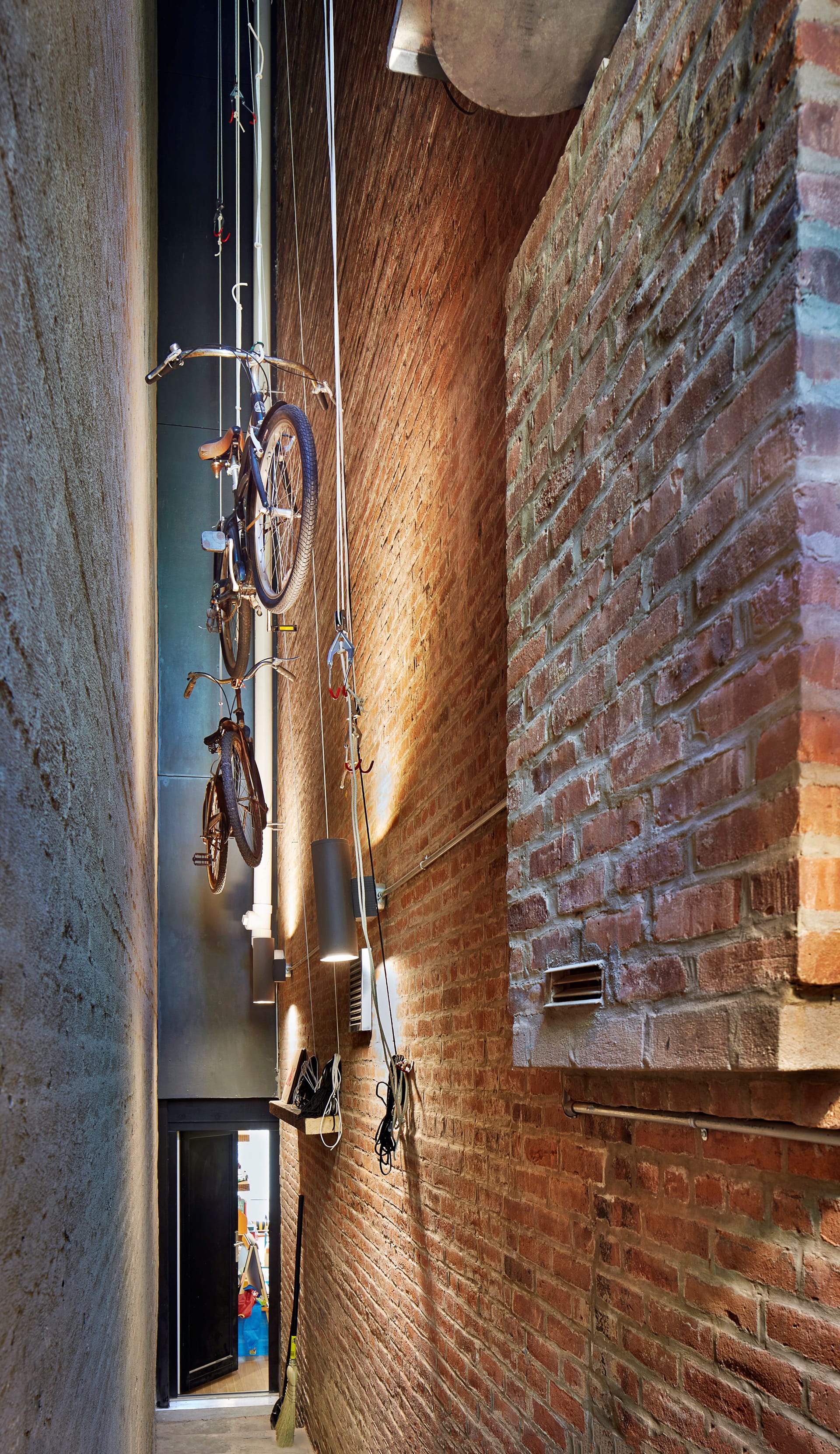 Brick alley with two bikes suspended in the air.