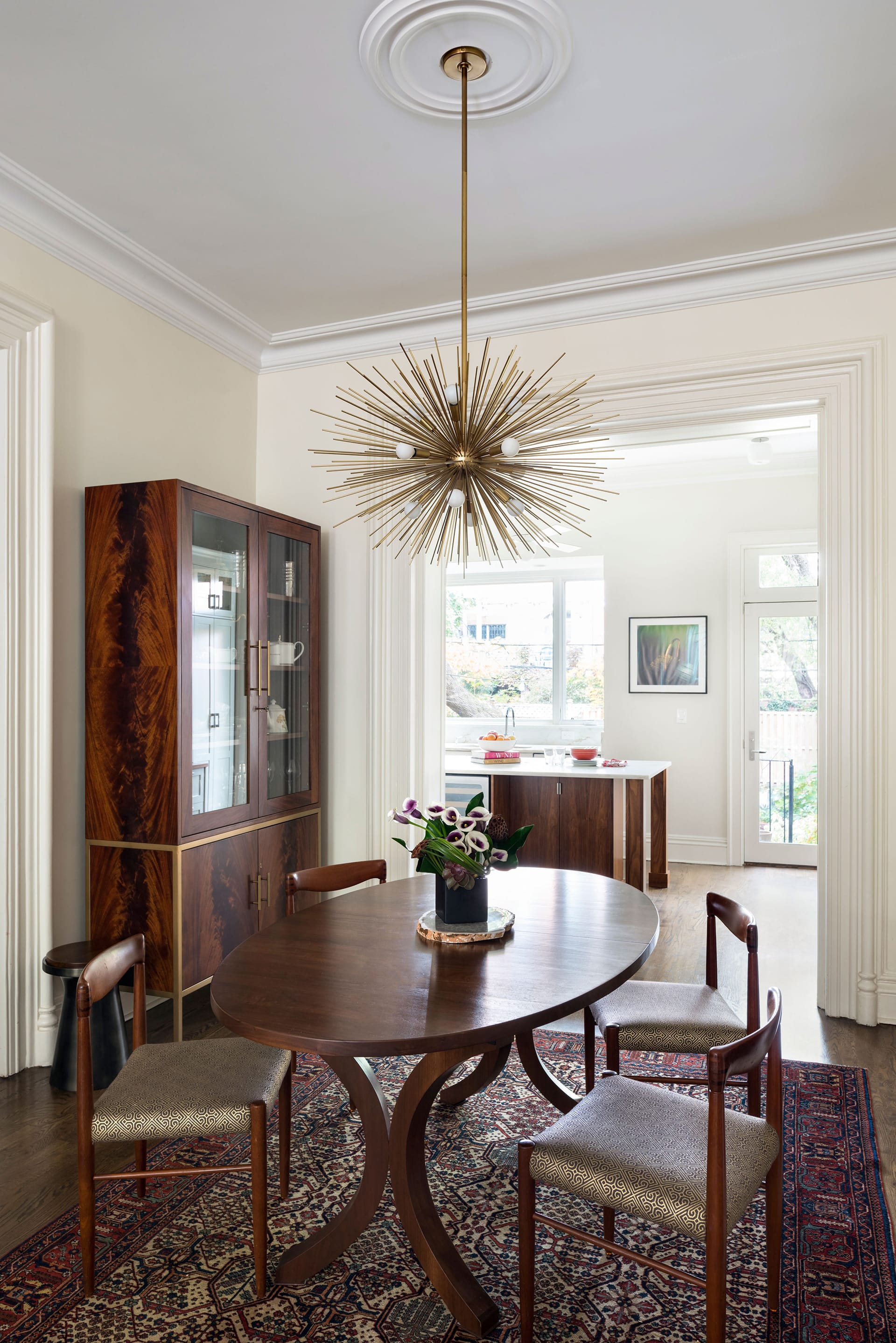 Dining room after our renovation, with increased natural light, new furnishings, and a statement light fixture