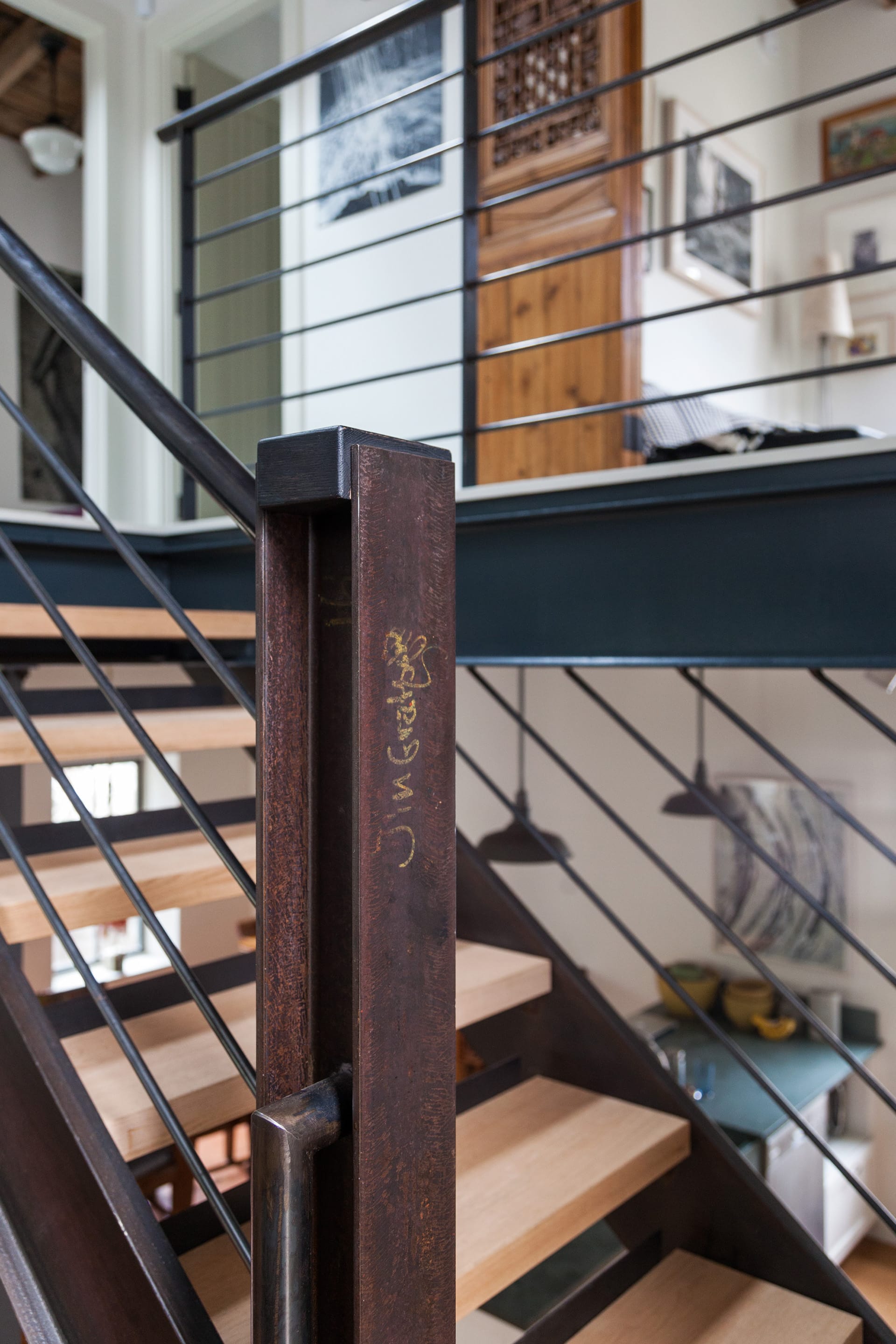 Metal newel post and railings in detail on a modern staircase.