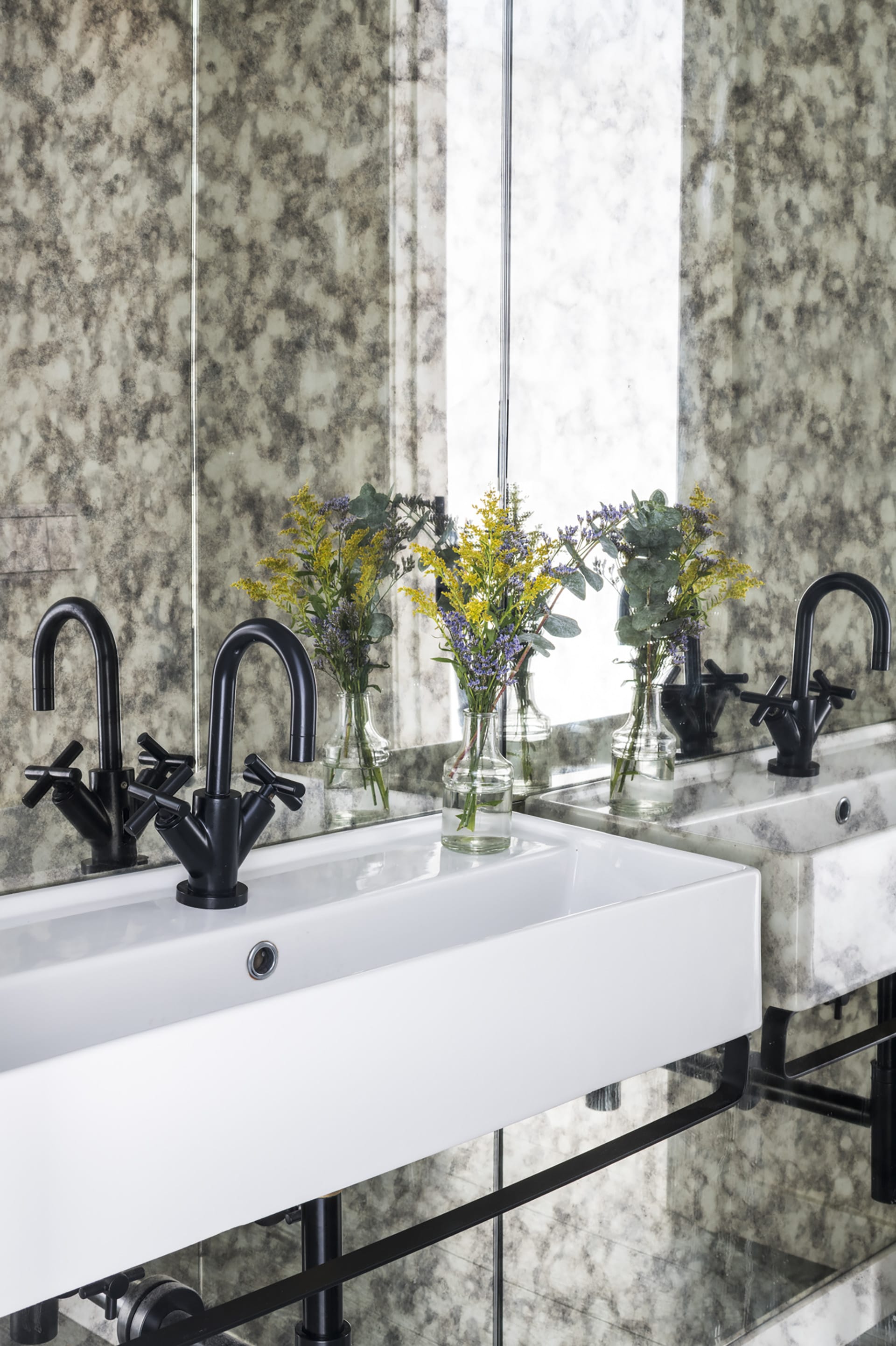 Powder room with patterned wallpaper, black fixtures, and yellow flowers