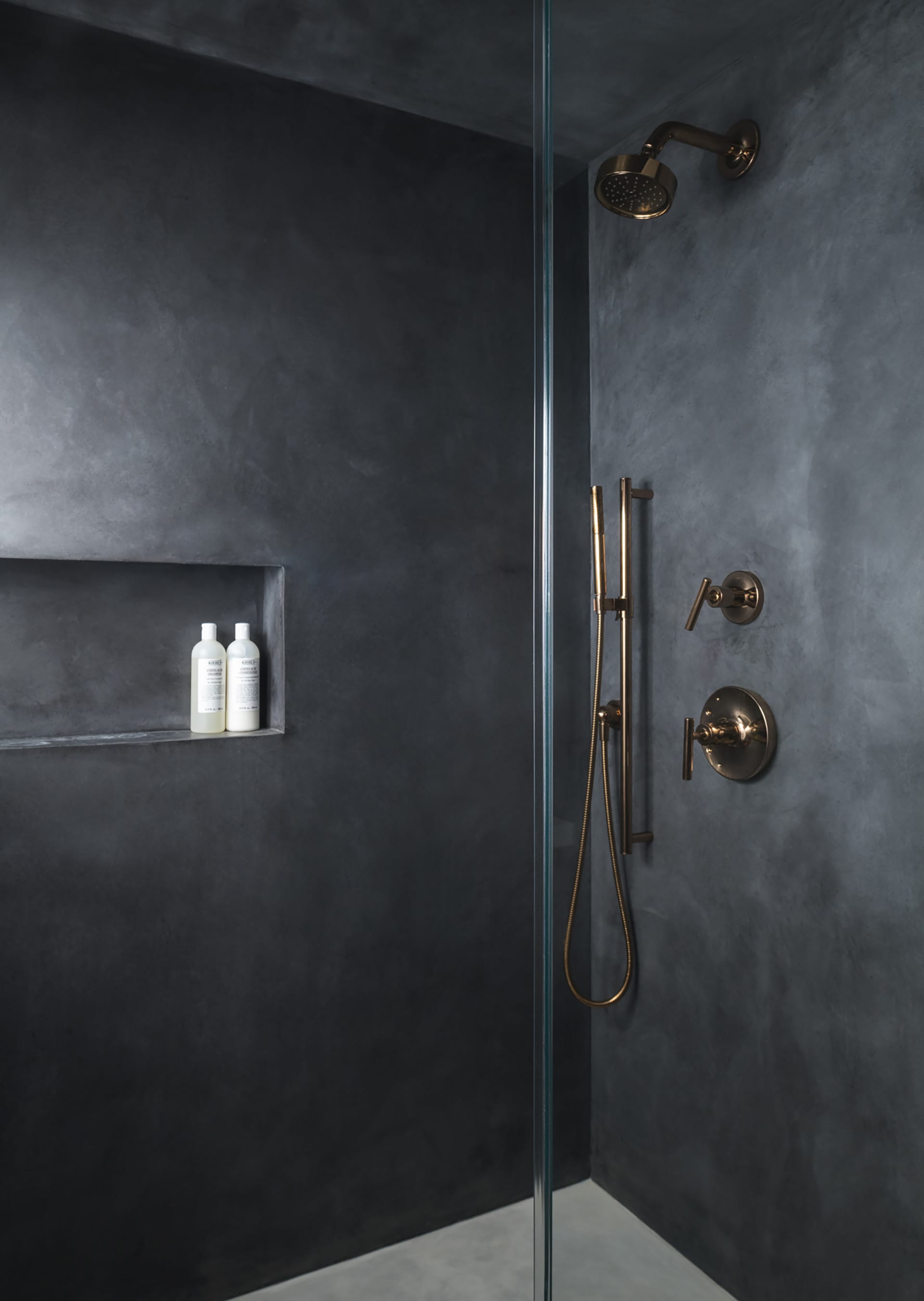 Guest shower with rose gold fixtures and Cementous walls