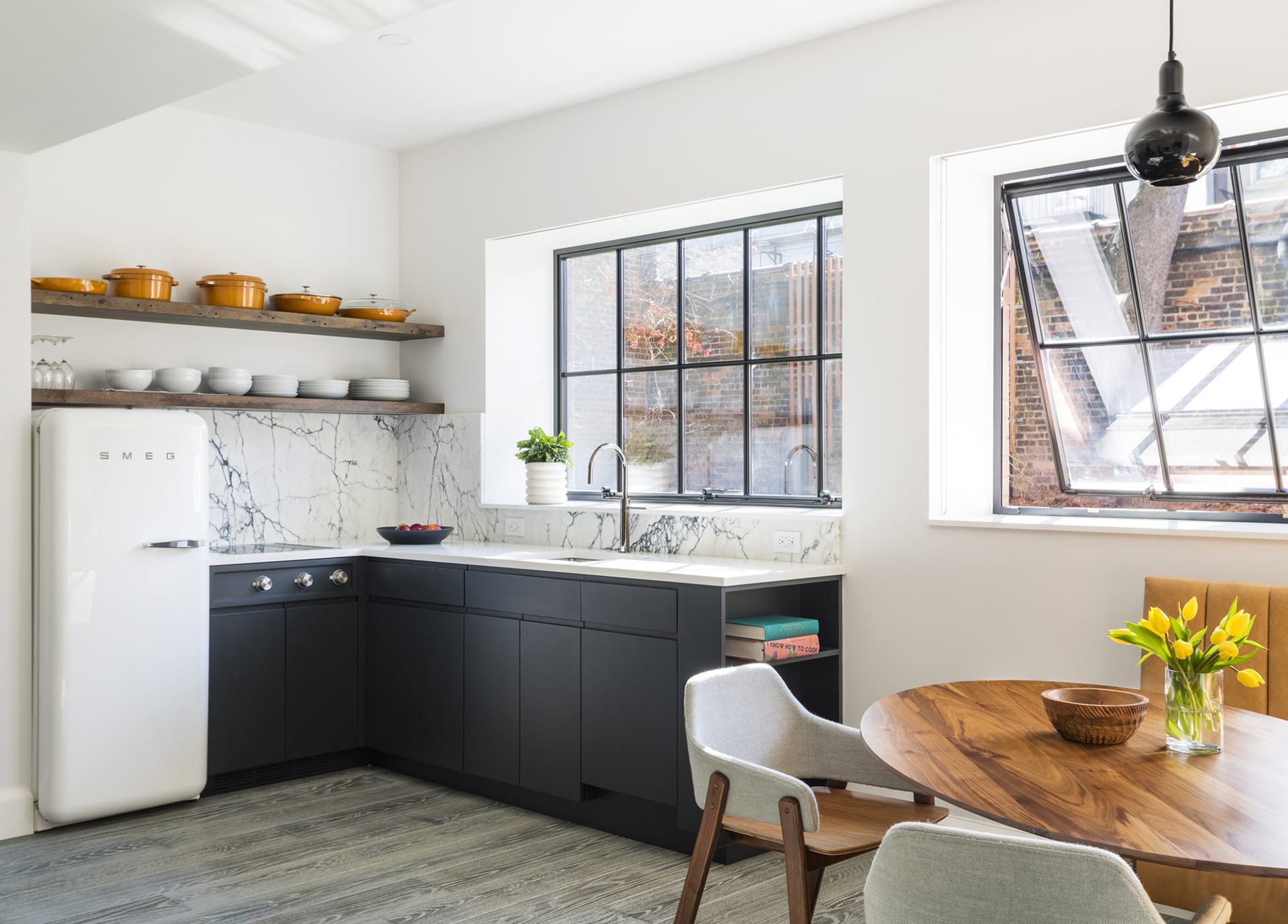 Kitchenette with a Smeg refrigerator and black cabinetry in a garden-level Brooklyn Heights apartment