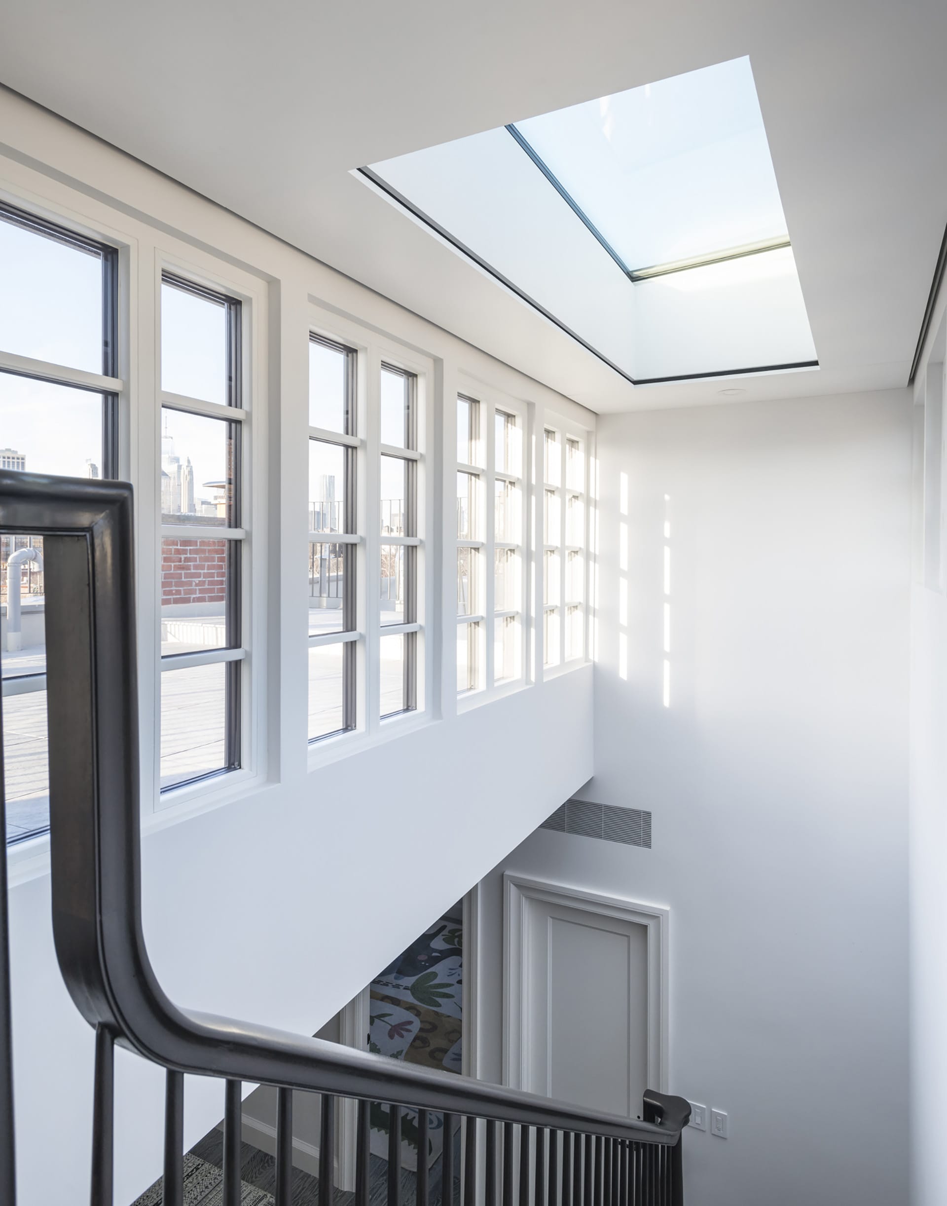 Interior of a bulkhead lined with windows and a skylight over the main staircase