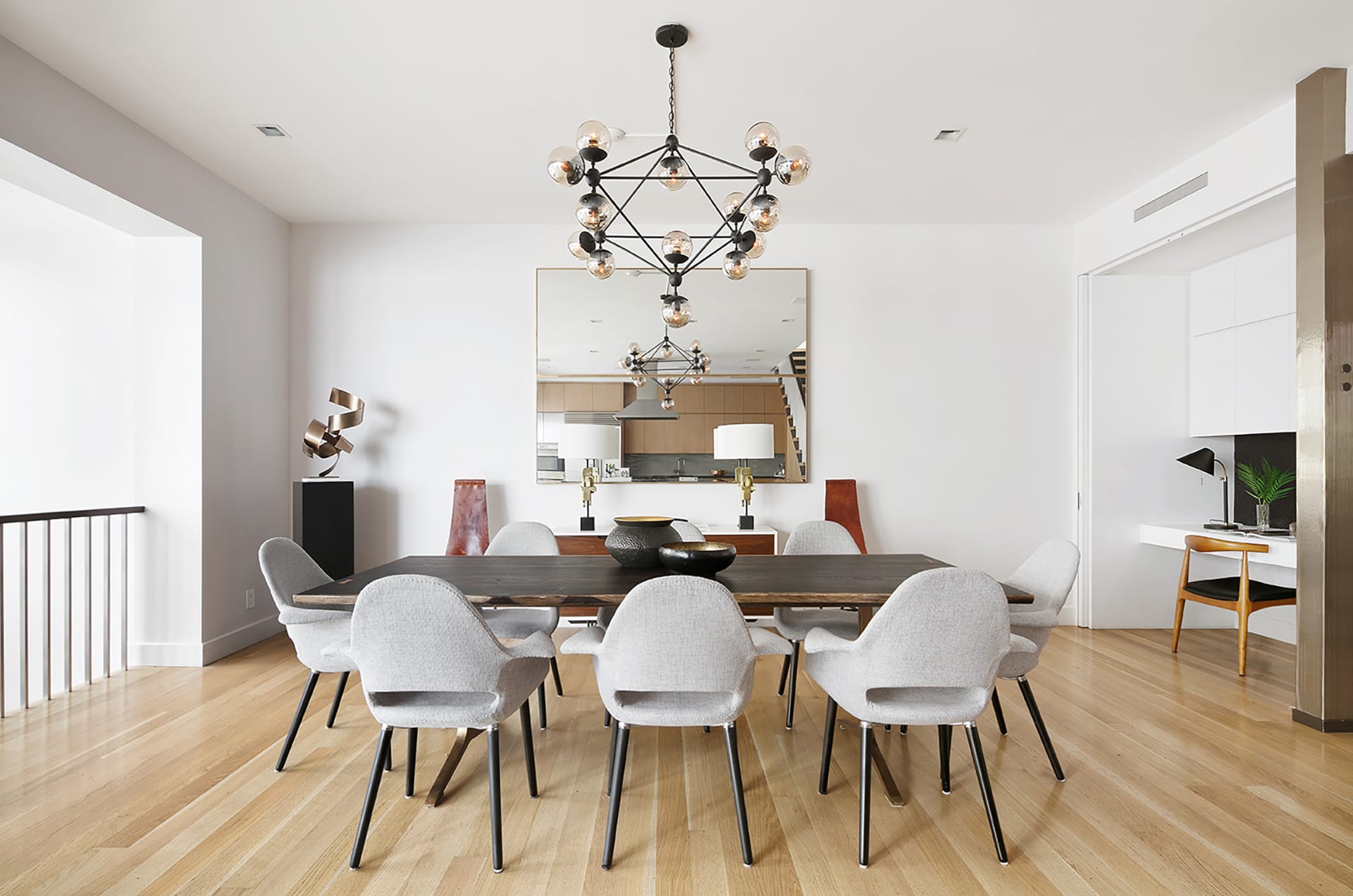 Dining area in with grey chairs and a modern chandelier in a Brooklyn Heights carriage house