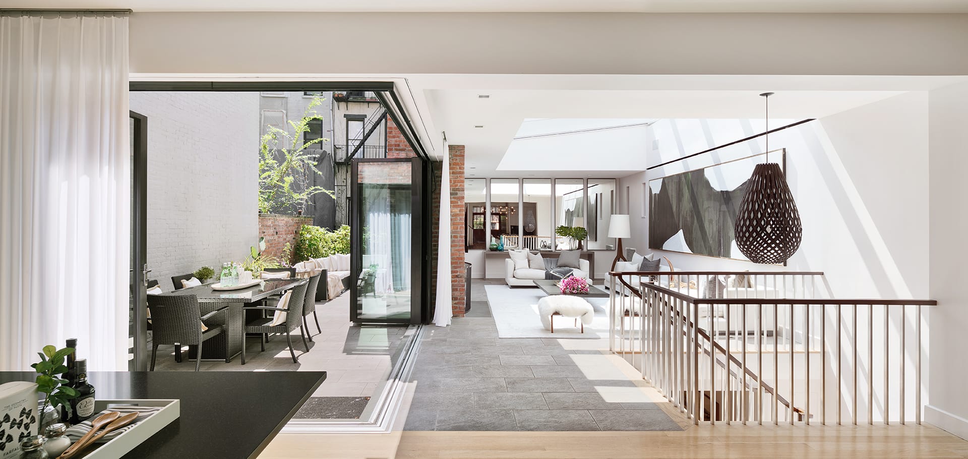 Living area with a large NanaWall sliding glass door system that opens the living room completely to the outdoor dining area.