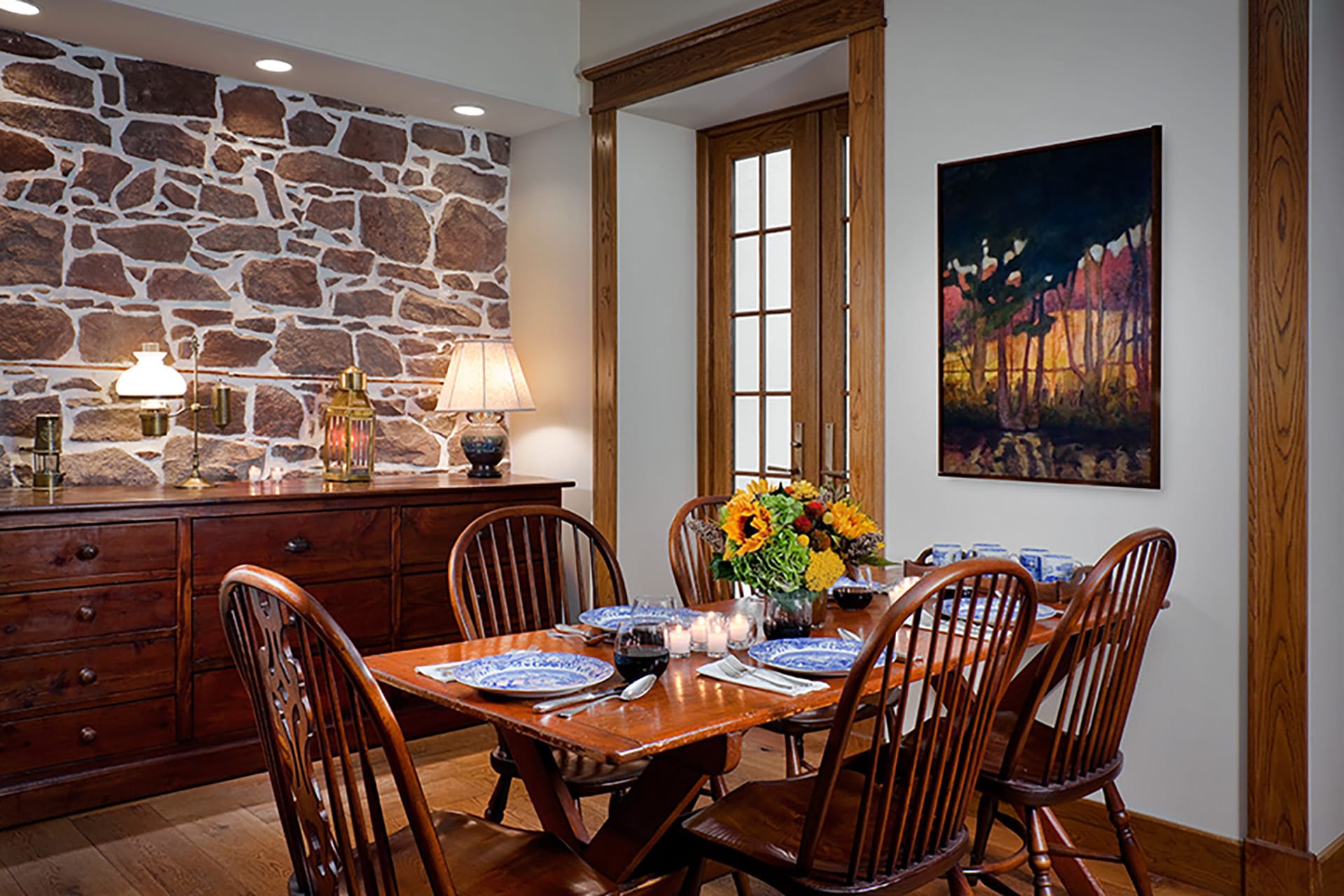 Dining room with a wood table, chairs, and molding, and an original brownstone accent wall