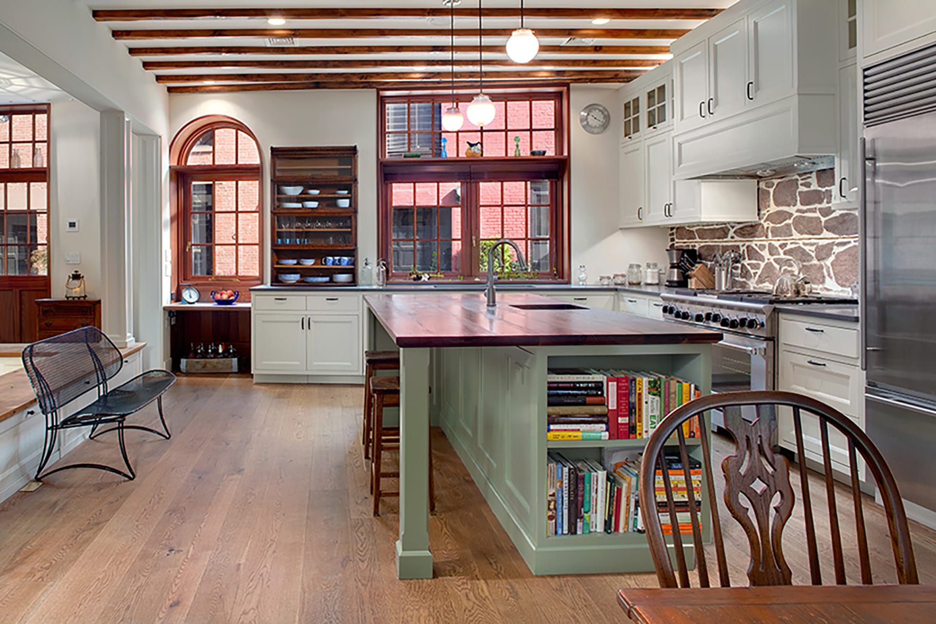 Kitchen with orignal brownstone backsplash, a green island, and large windows
