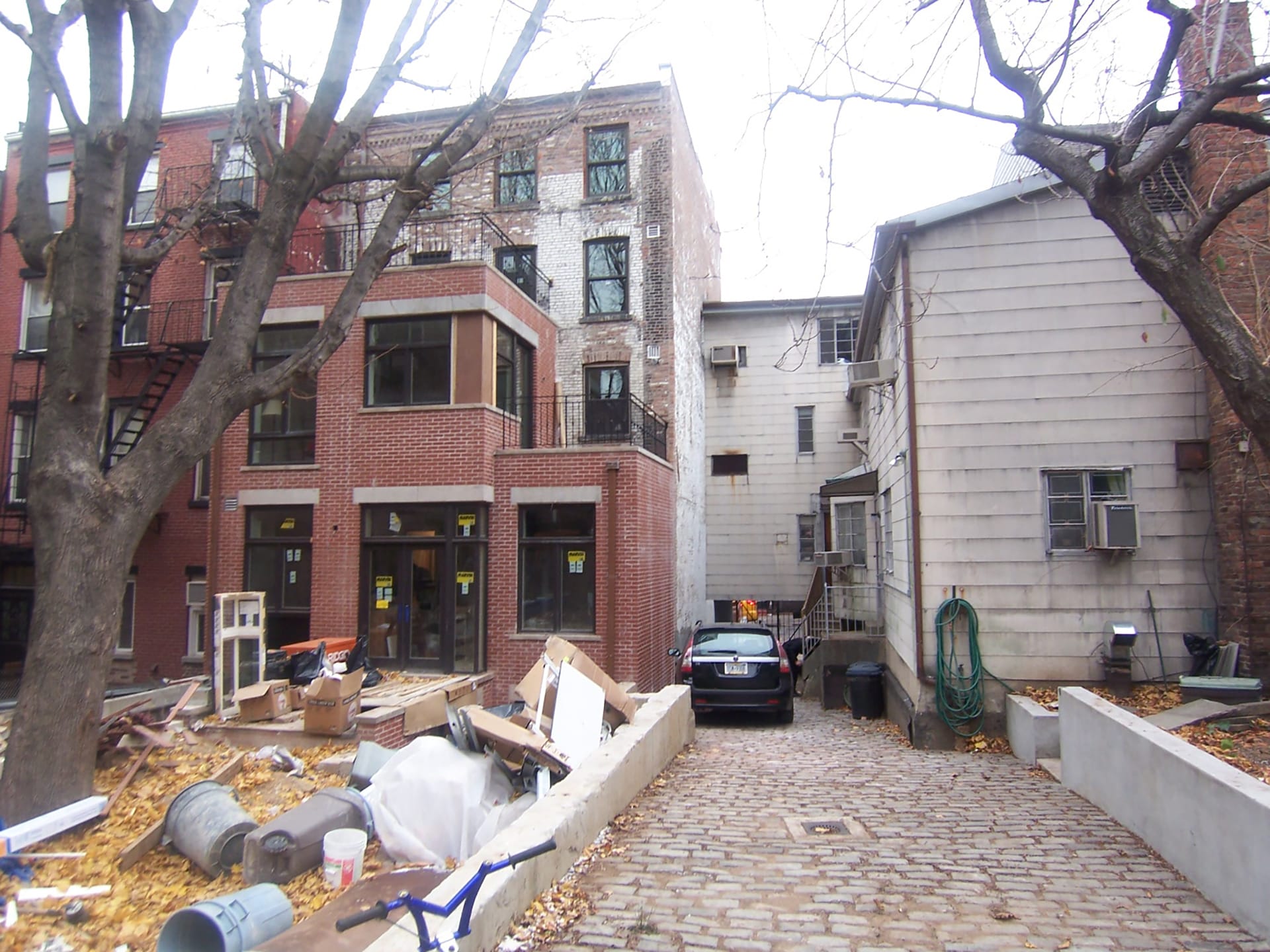 Rear façade with paved driveway and wide white siding