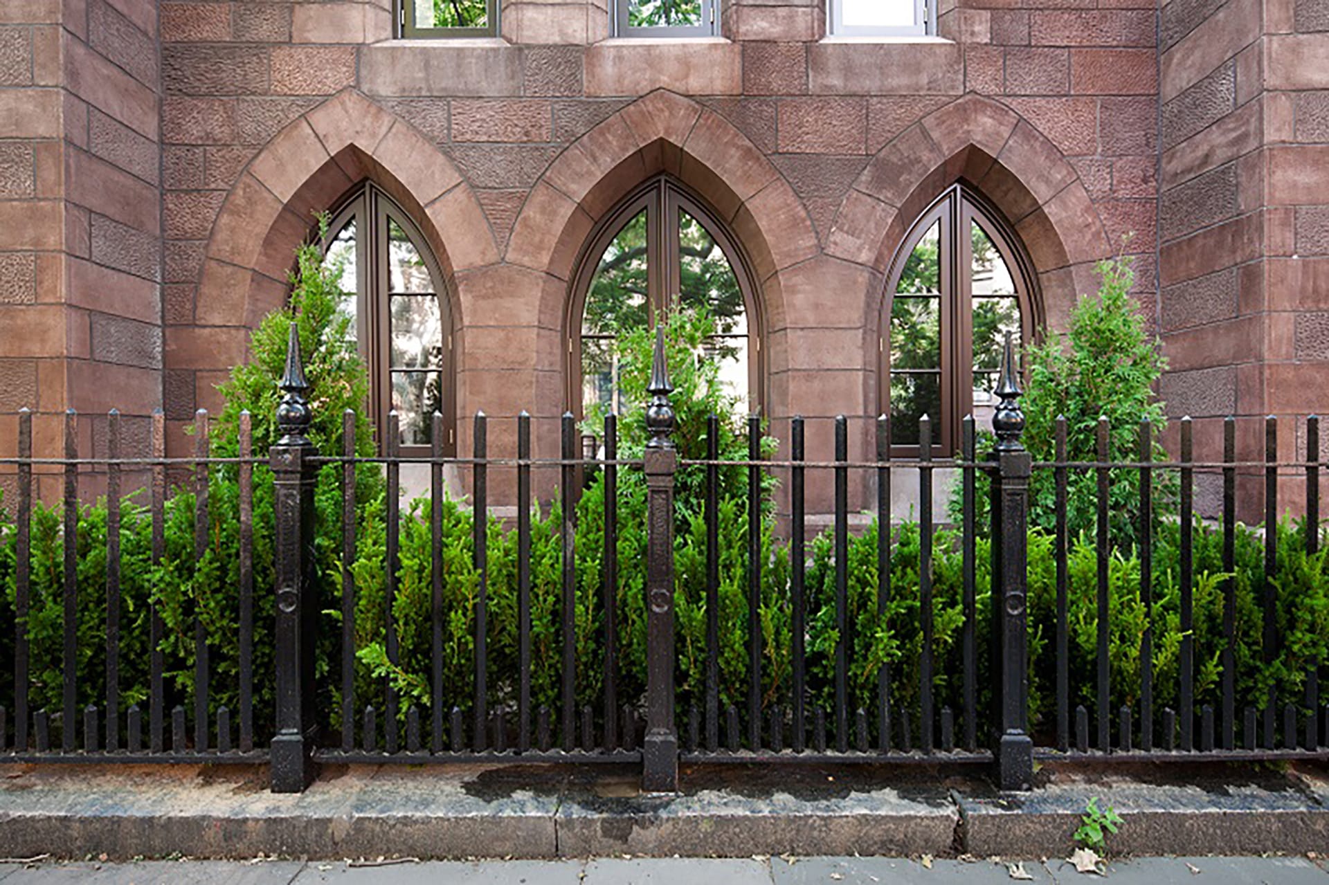 Exterior of a Brooklyn church after our renovation, with a restored fence and brownstone façade
