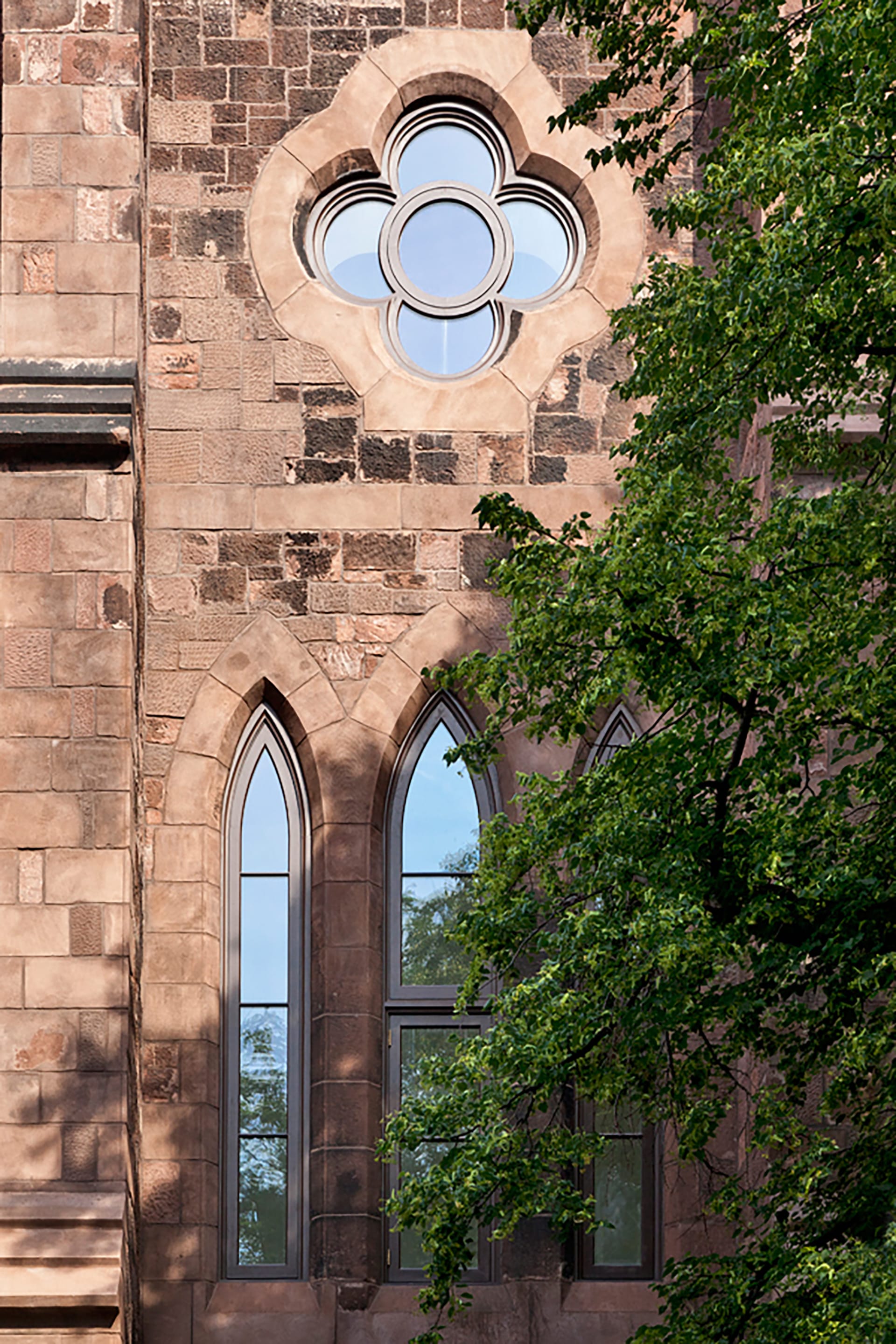Brownstone details and a flower-shaped window on the exterior of a church converted into condos