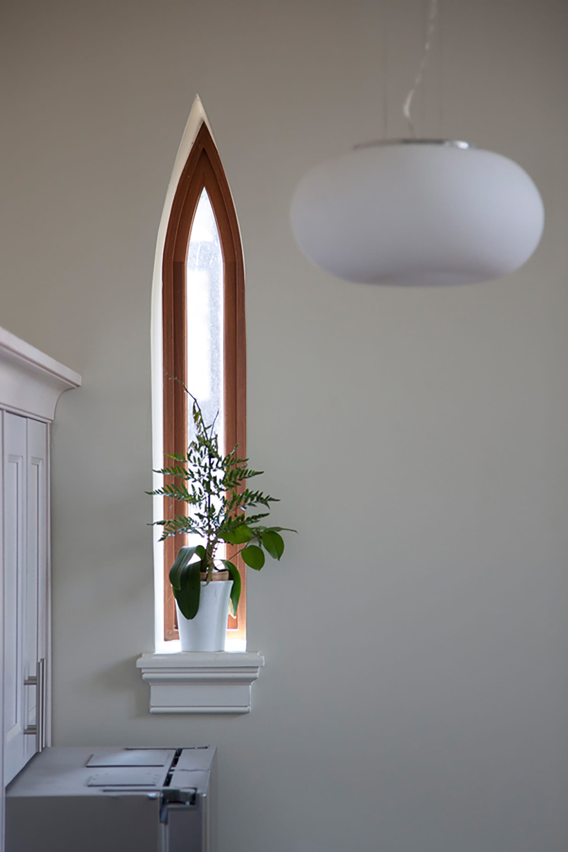 Pointed, narrow window with a houseplant on the window sill
