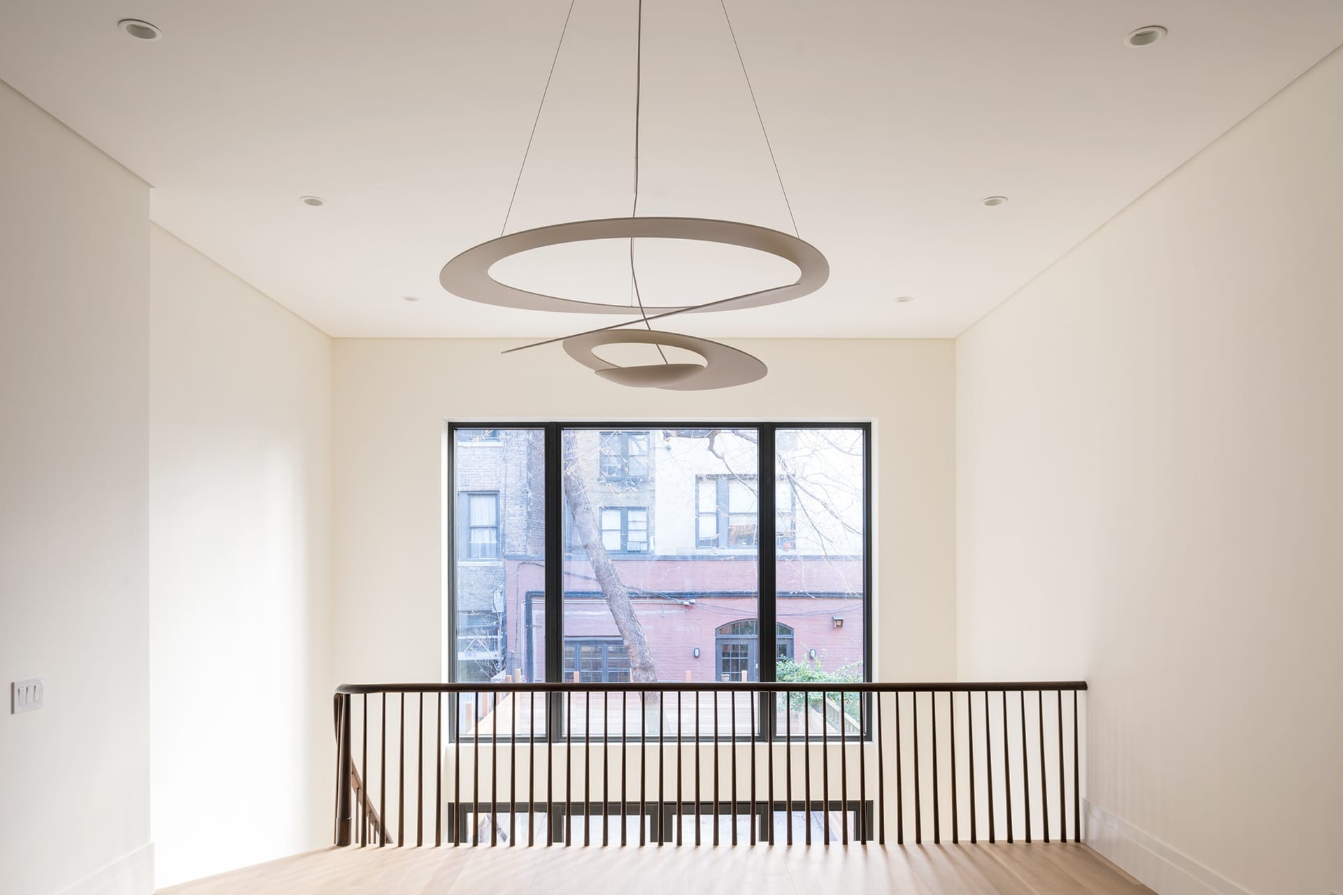 Double height space, large window and chandelier in an Upper West Side Passive House