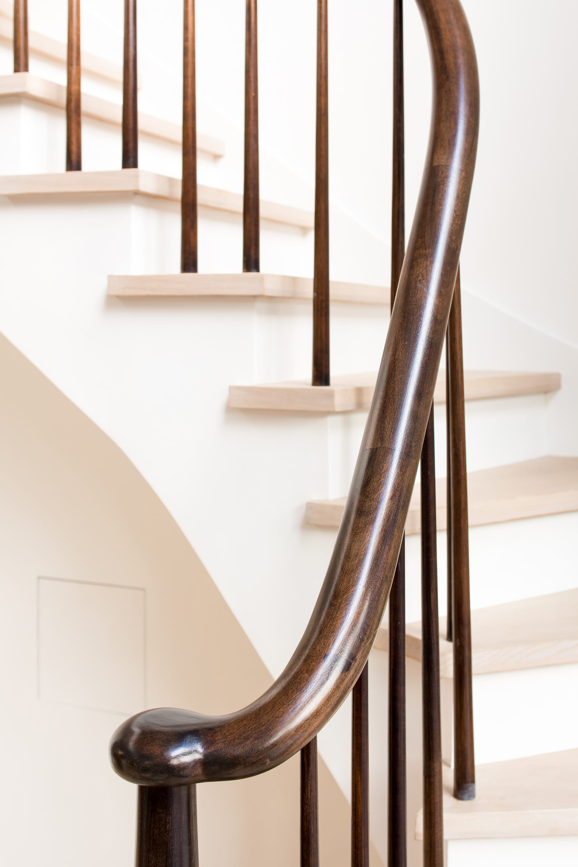 White oak staircase and mahogany handrail and balusters in an Upper West Side Passive House.