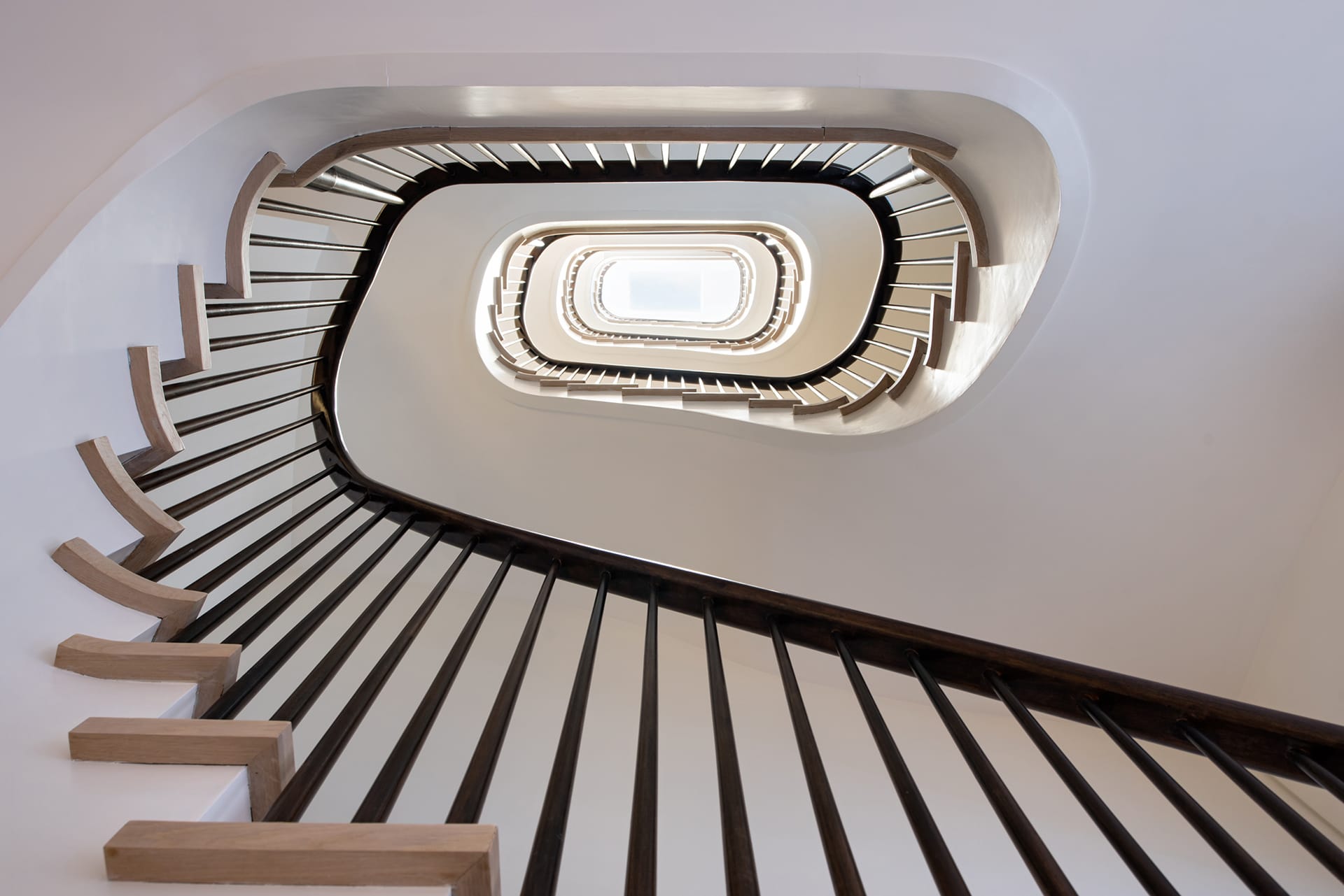 White oak staircase and mahogany handrail and balusters in an Upper West Side Passive House.