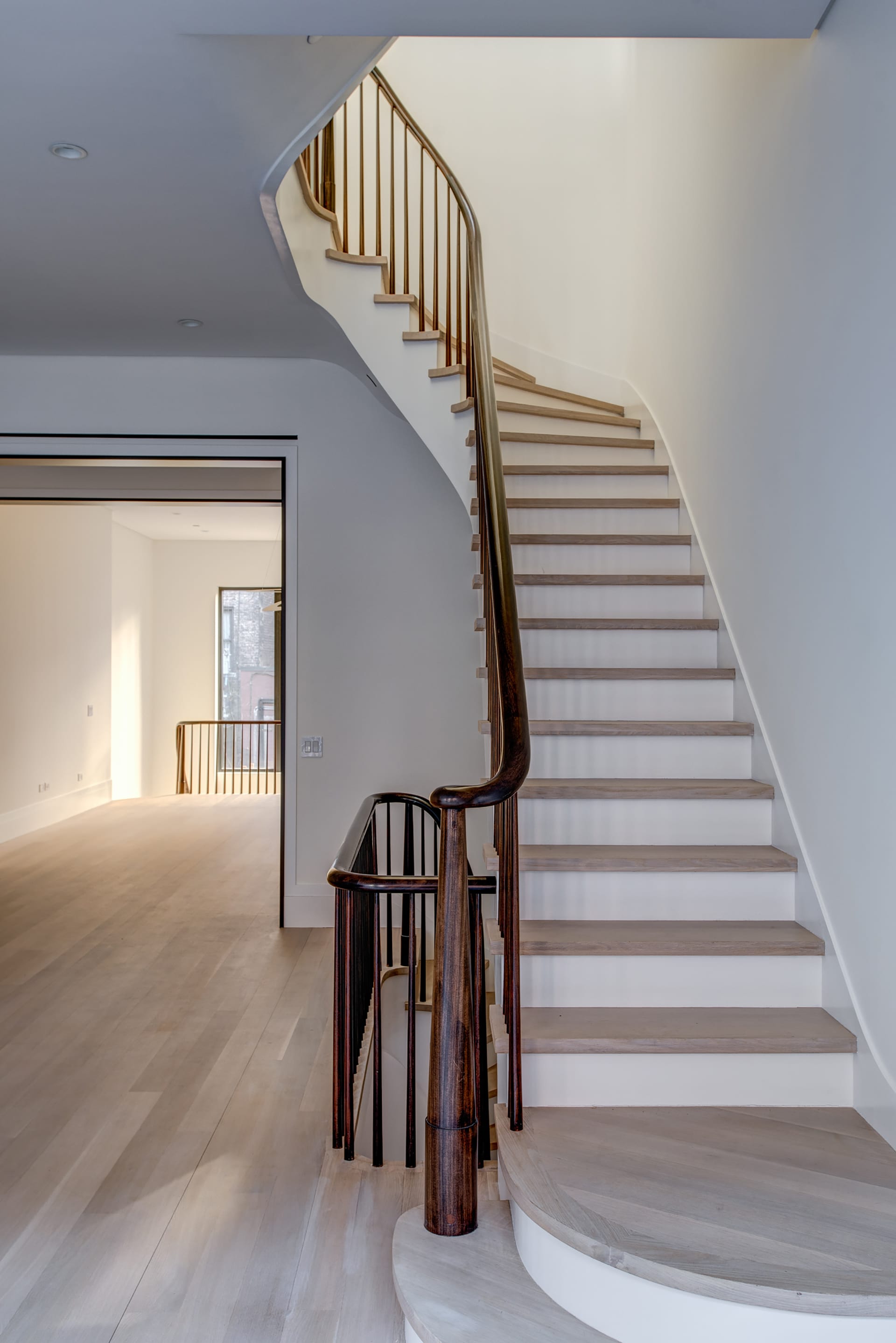 White oak staircase and mahogany handrail and balusters in an Upper West Side Passive House.