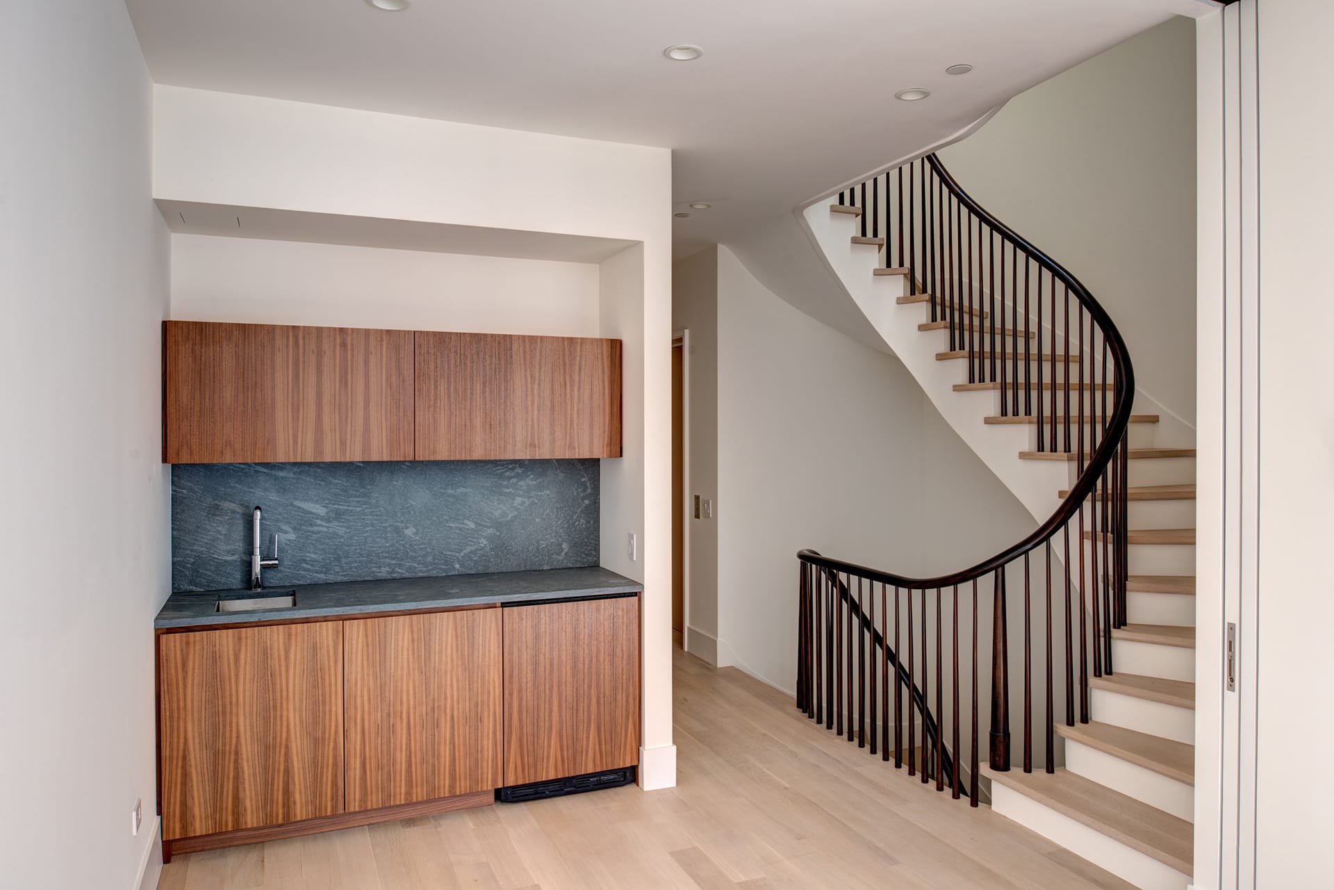 White oak and mahogany staircase and built-in wet bar in an Upper West Side Passive House.