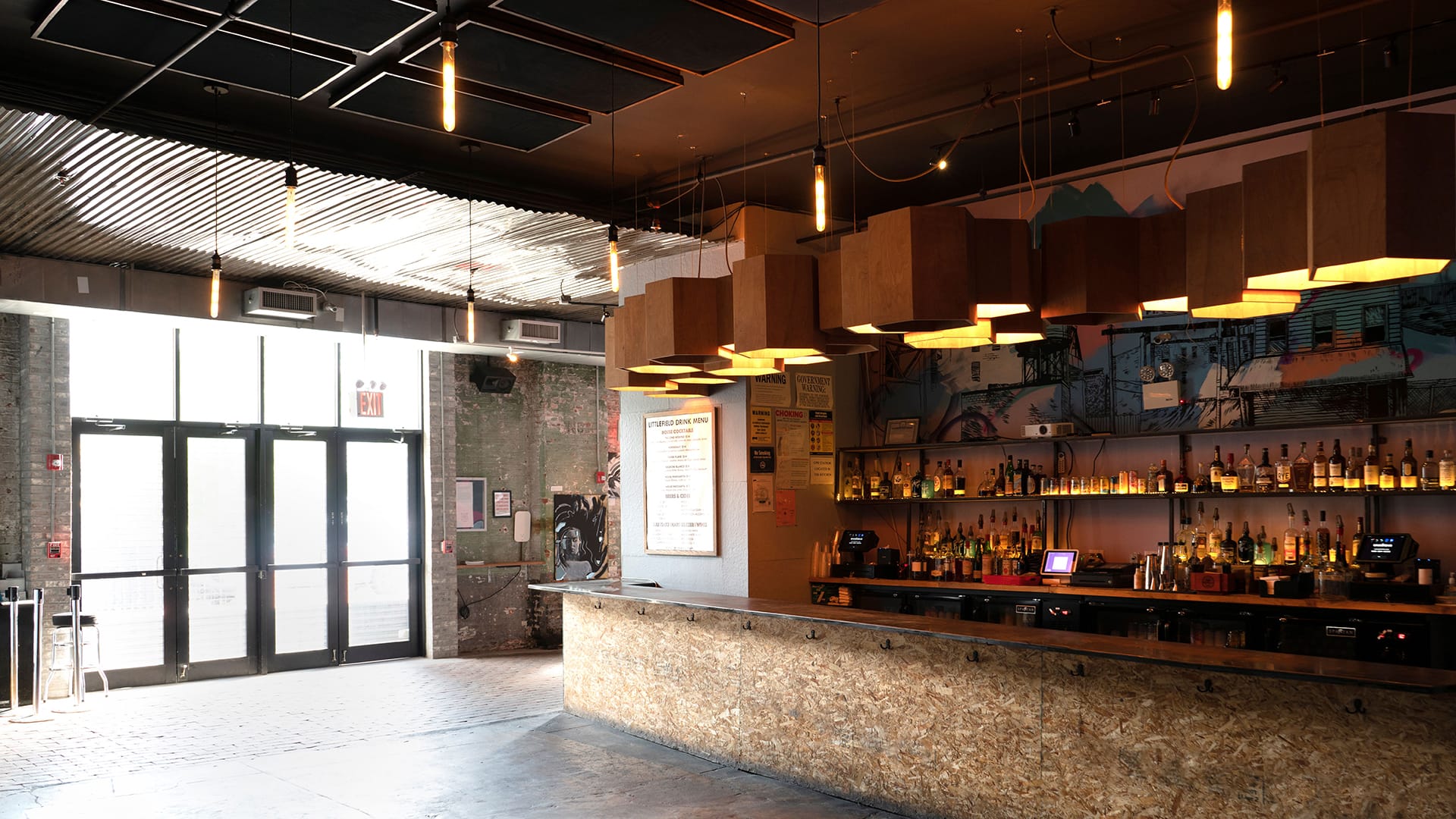 Bar and front doors of Littlefield from the inside. The doors are on the left side of the frame, and the bar is on the right.